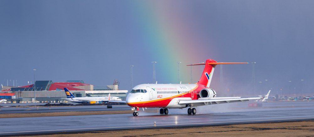 A COMAC ARJ21 in front of a rainbow