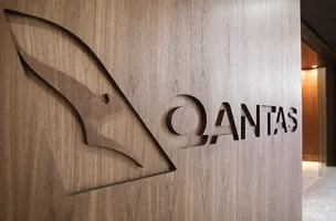 Qantas logo engraved on a wooden wall outside the first class lounge in Sydney Airport.