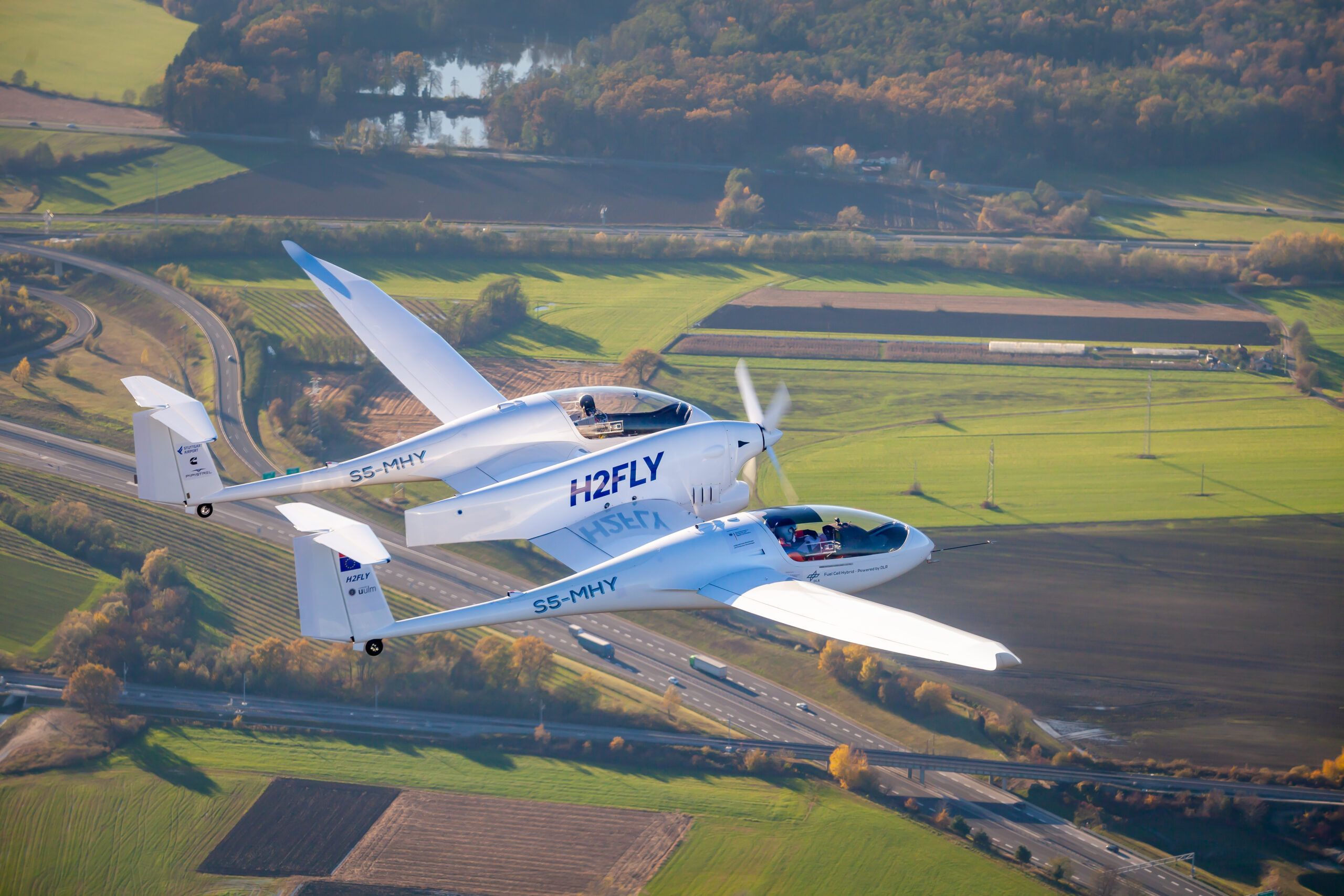 HY4 aircraft over green fields