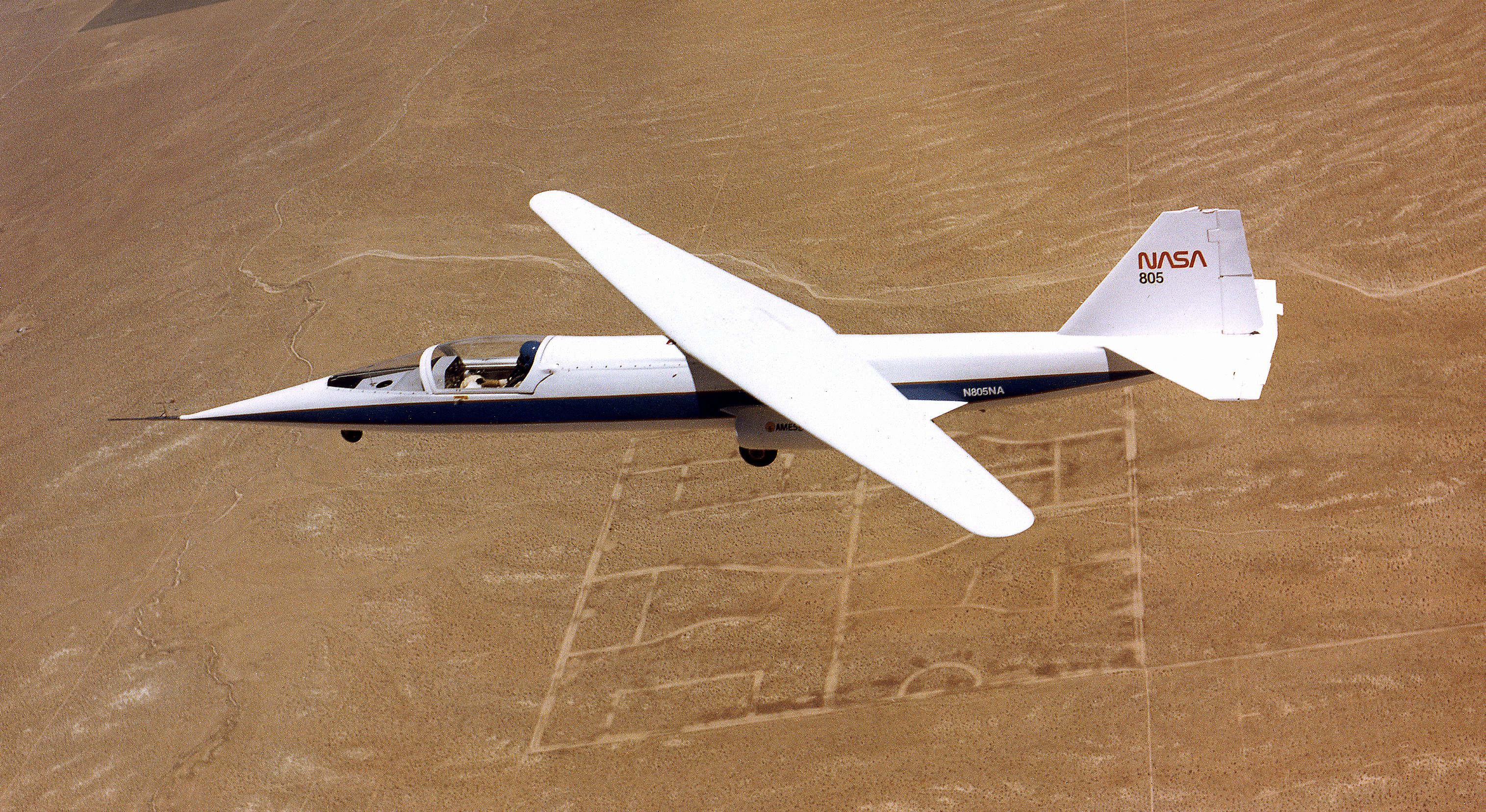 The NASA AD-1 aircraft in flight over a desert.