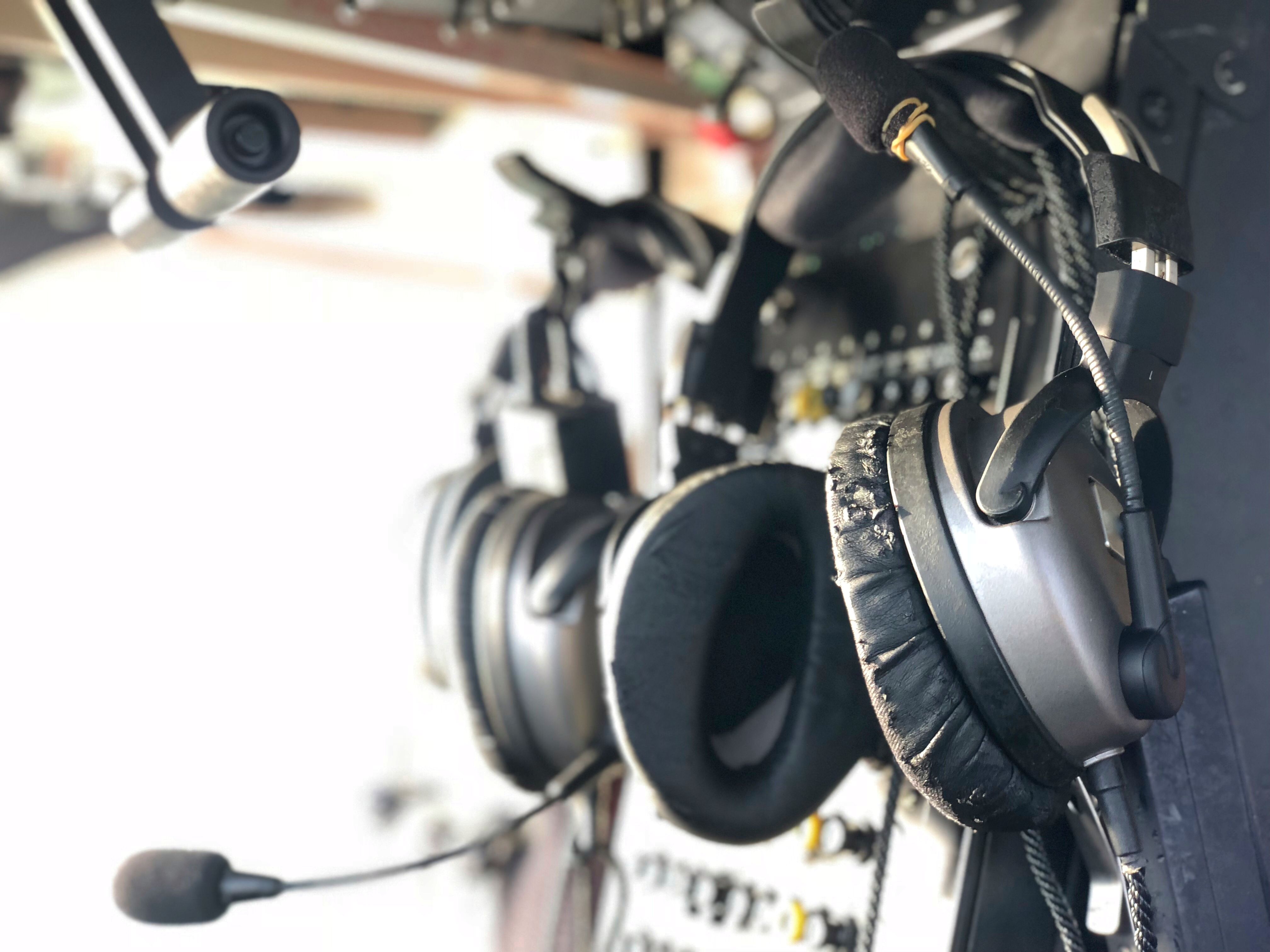 Pairs of headsets hanging on a flight deck wall.