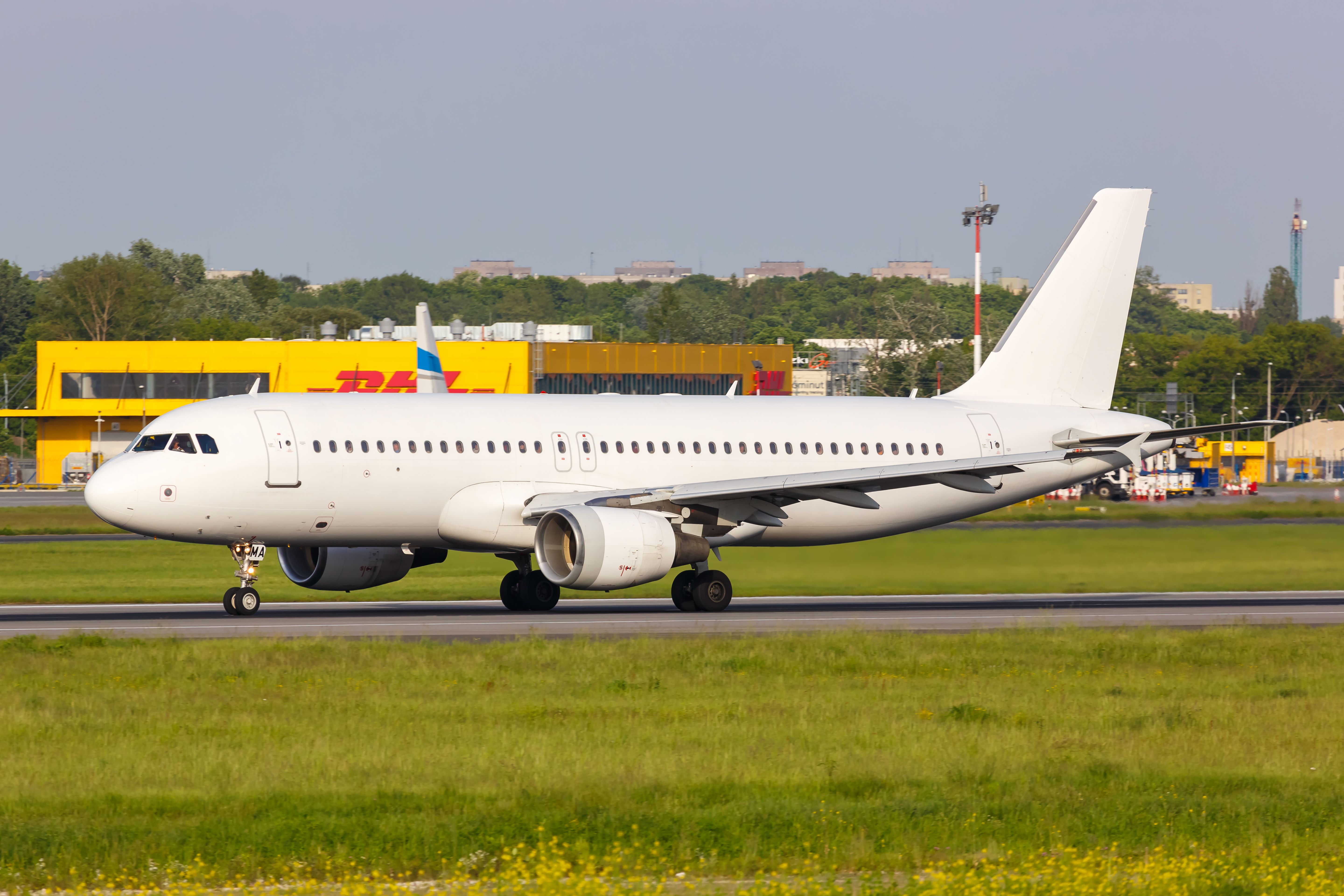 An all-white Airbus A320 on the runway.