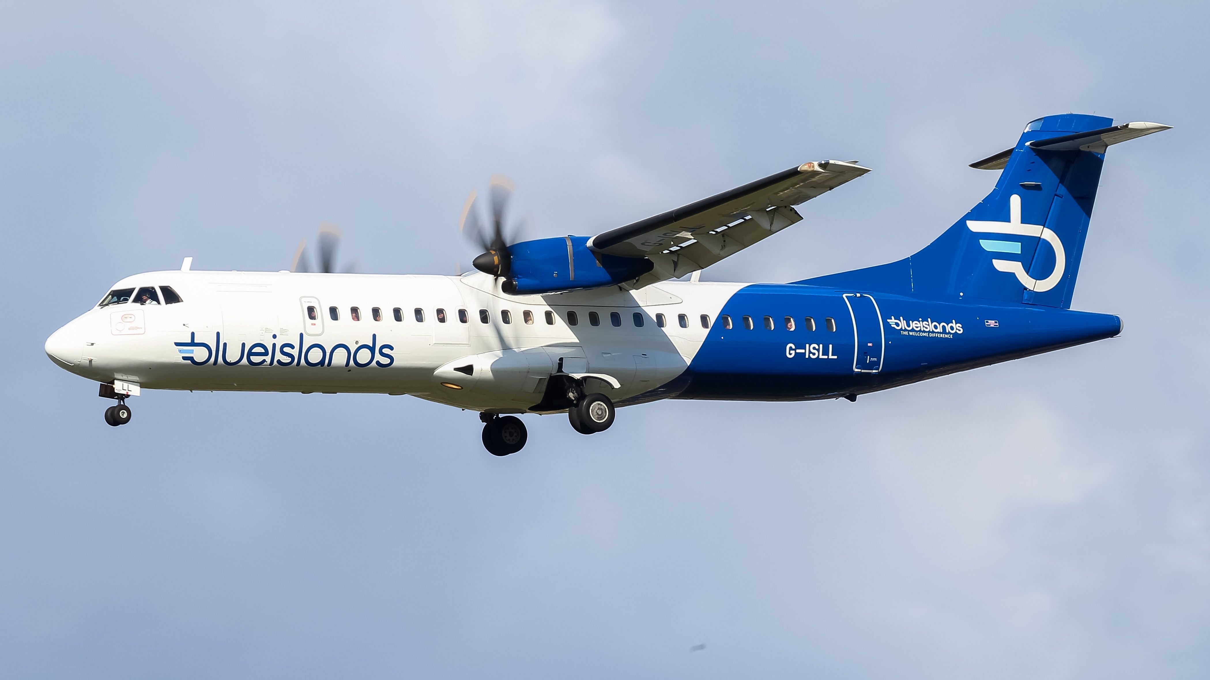 A Blue Islands ATR 72 flying low below the clouds.