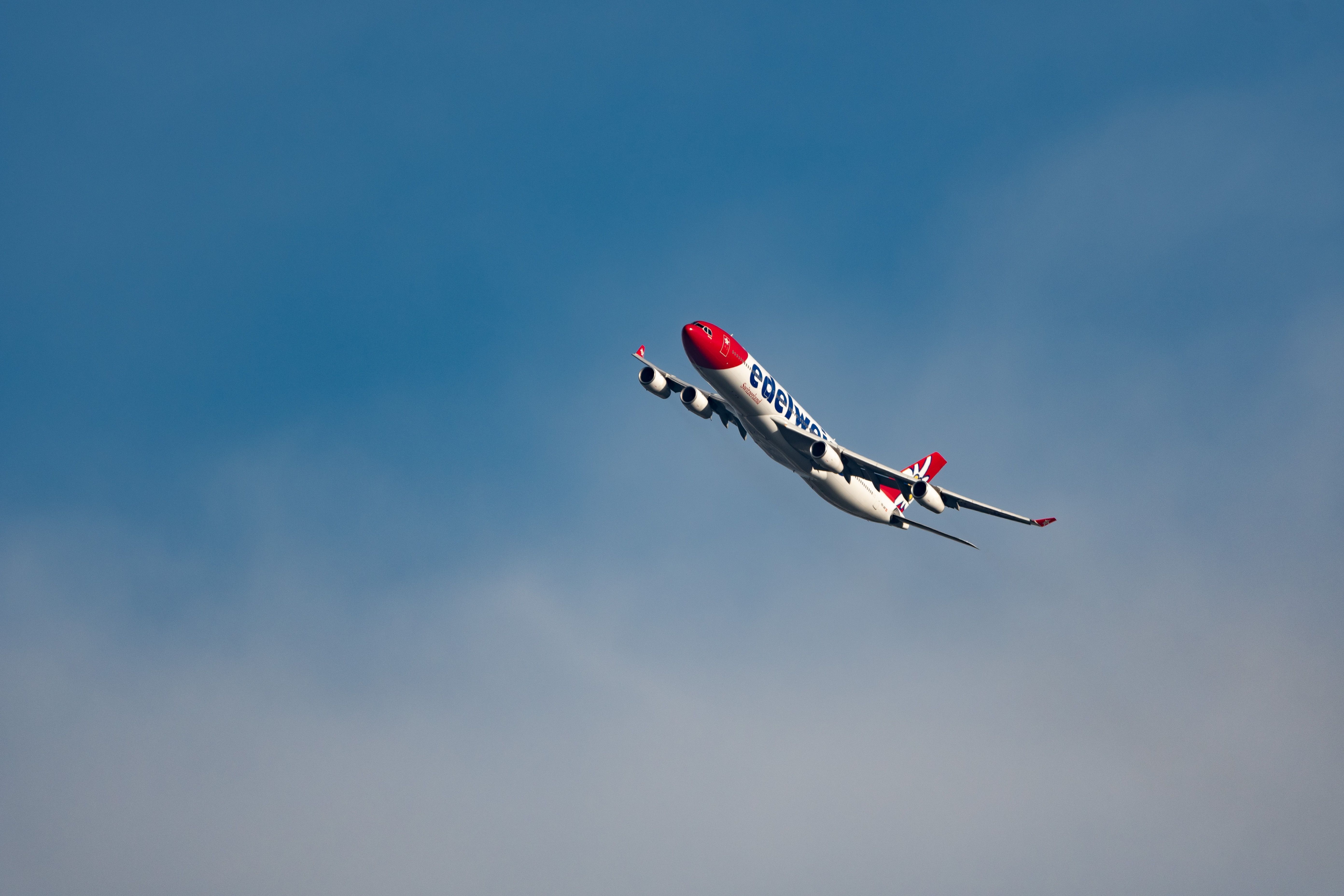 Edelweiss Airbus A340-313X overhead in the blue sky.
