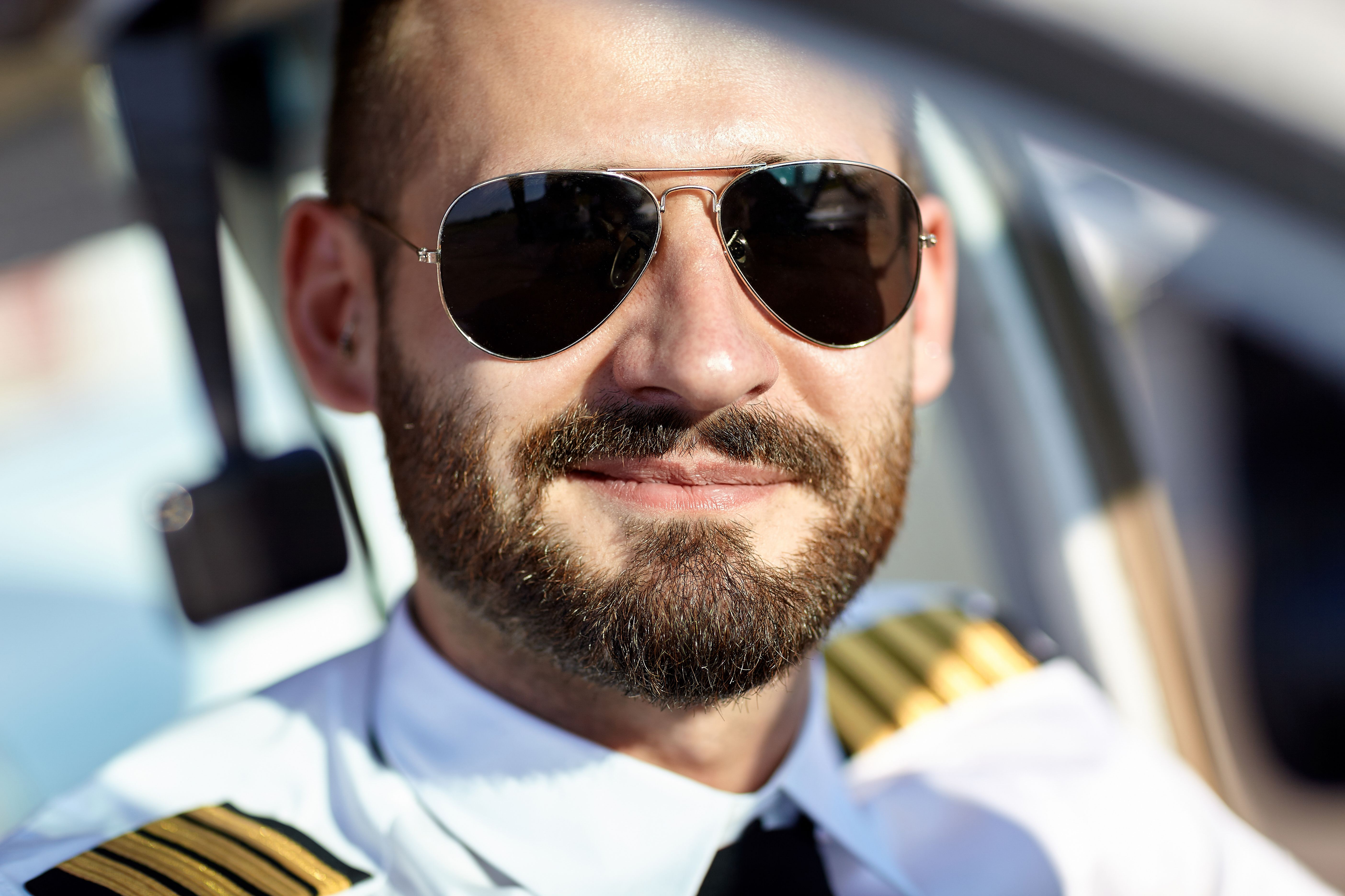 A pilot wearing aviator sunglasses on a sunny day.