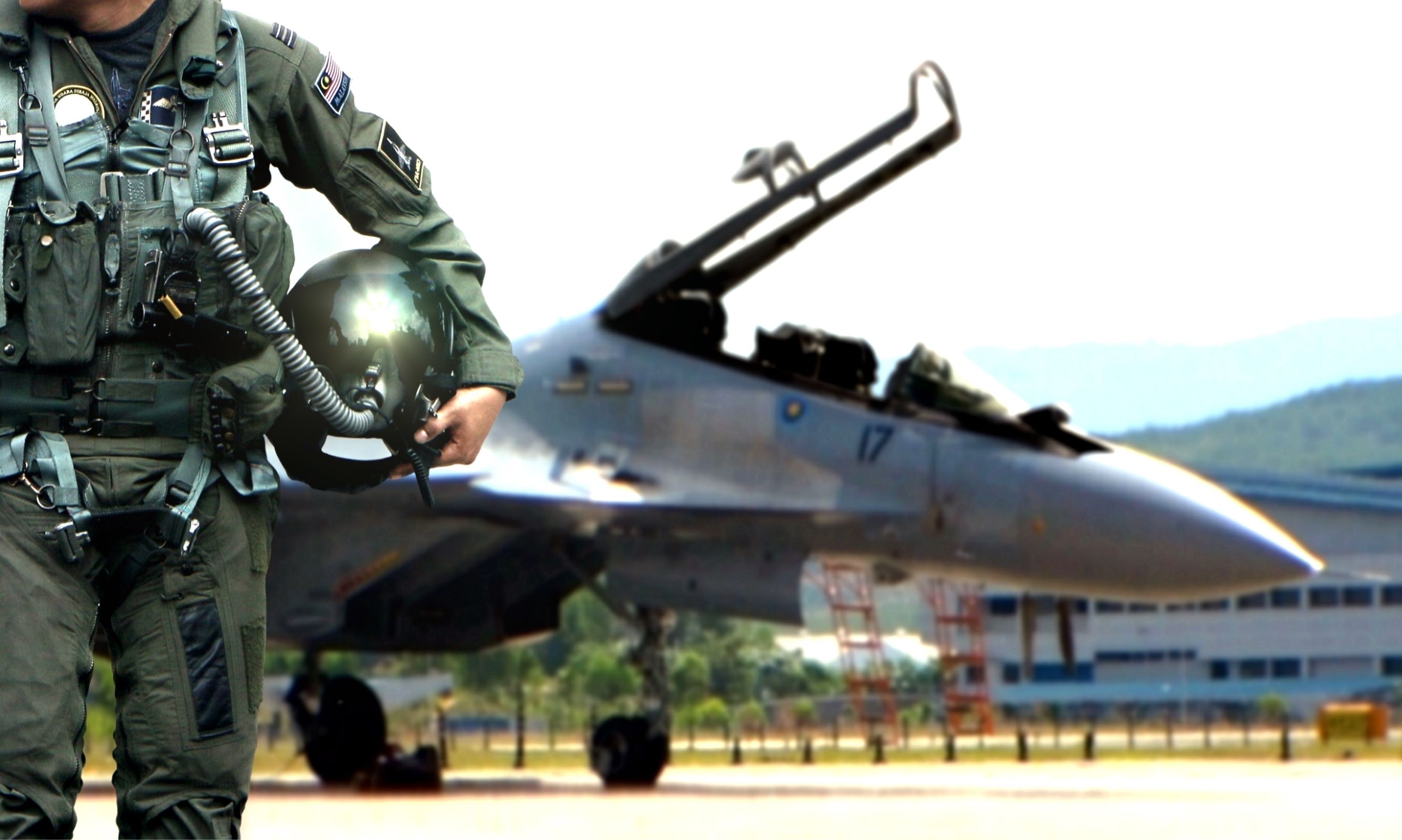 A military pilot walks away from their fighter jet.