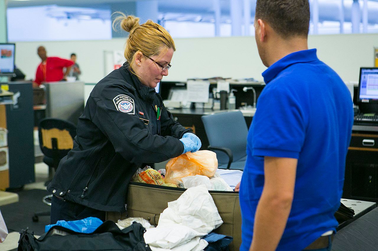 A CBP Agriculture Specialist processes a passenger who has food products in their luggage.