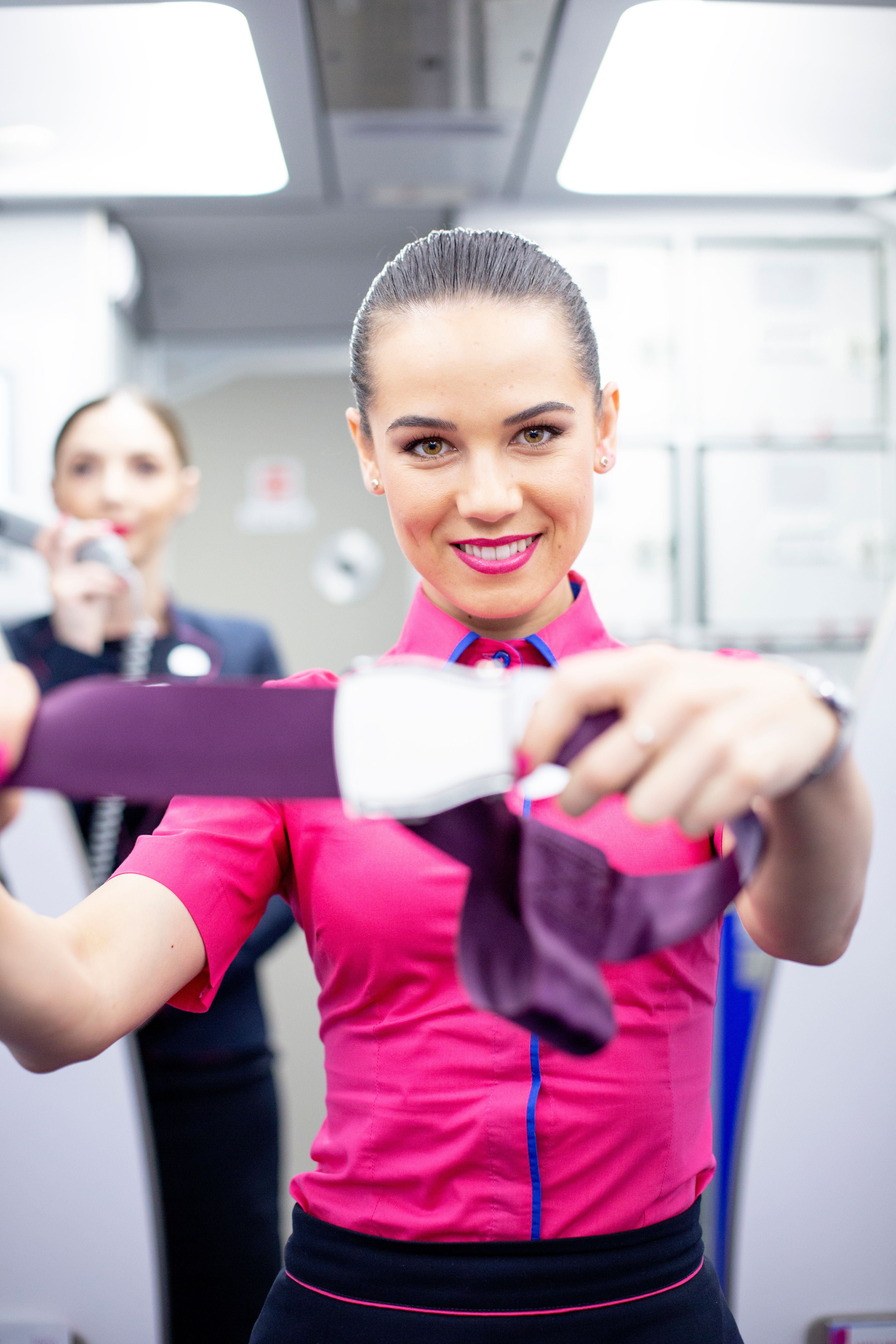 A wizz air cabin crew providing a safety demo.