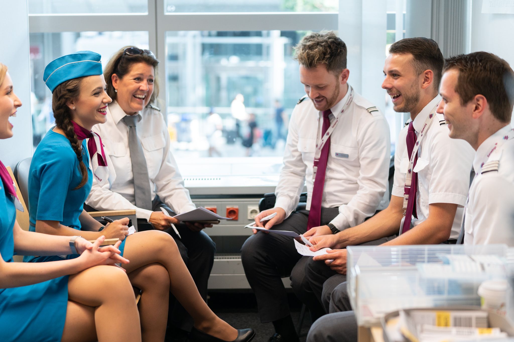 Cabin crew members discussing something during a pre-flight briefing.