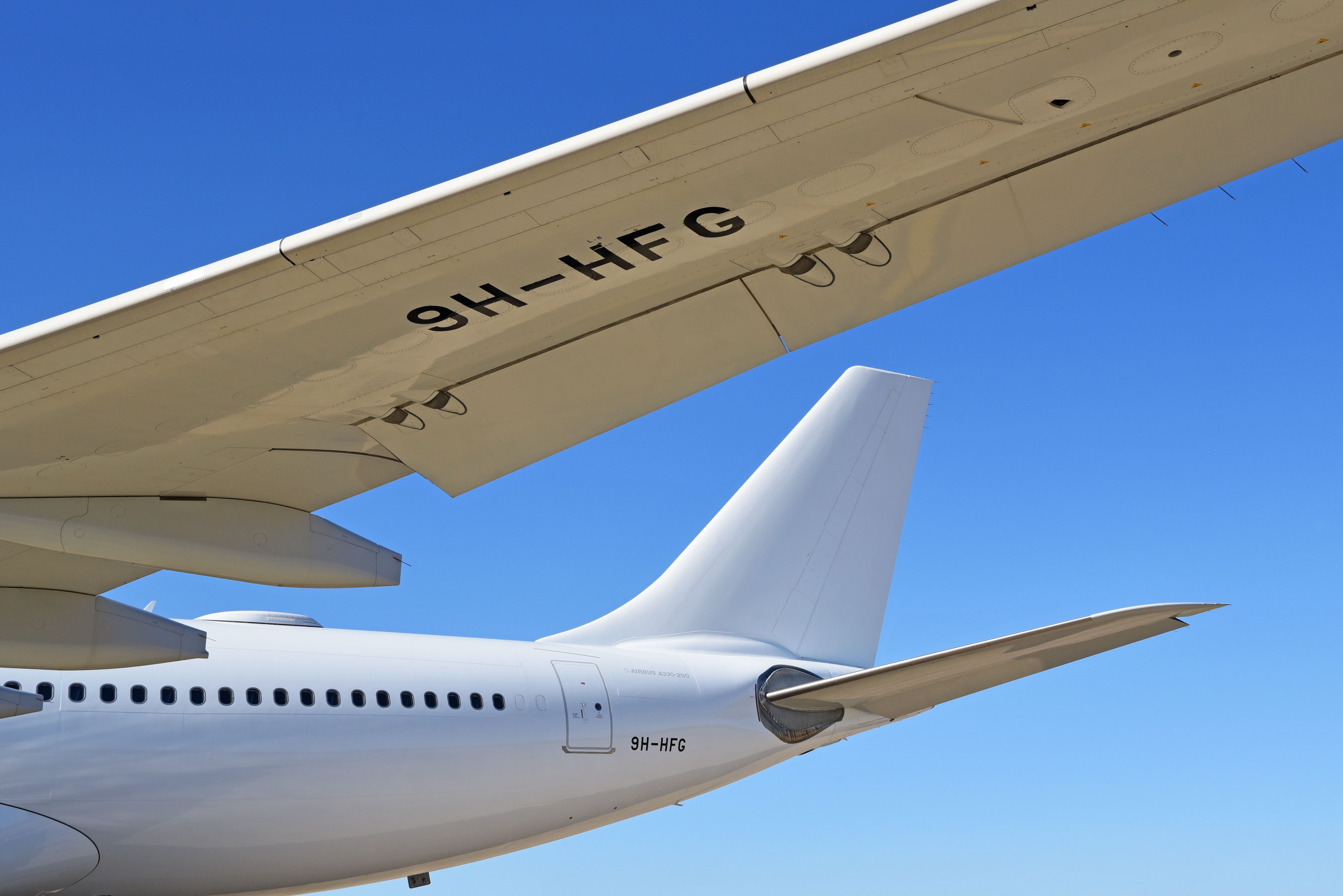 Hi Fly ex-KLM Airbus A330-300 (9H-HFG) wing and tail against blue sky