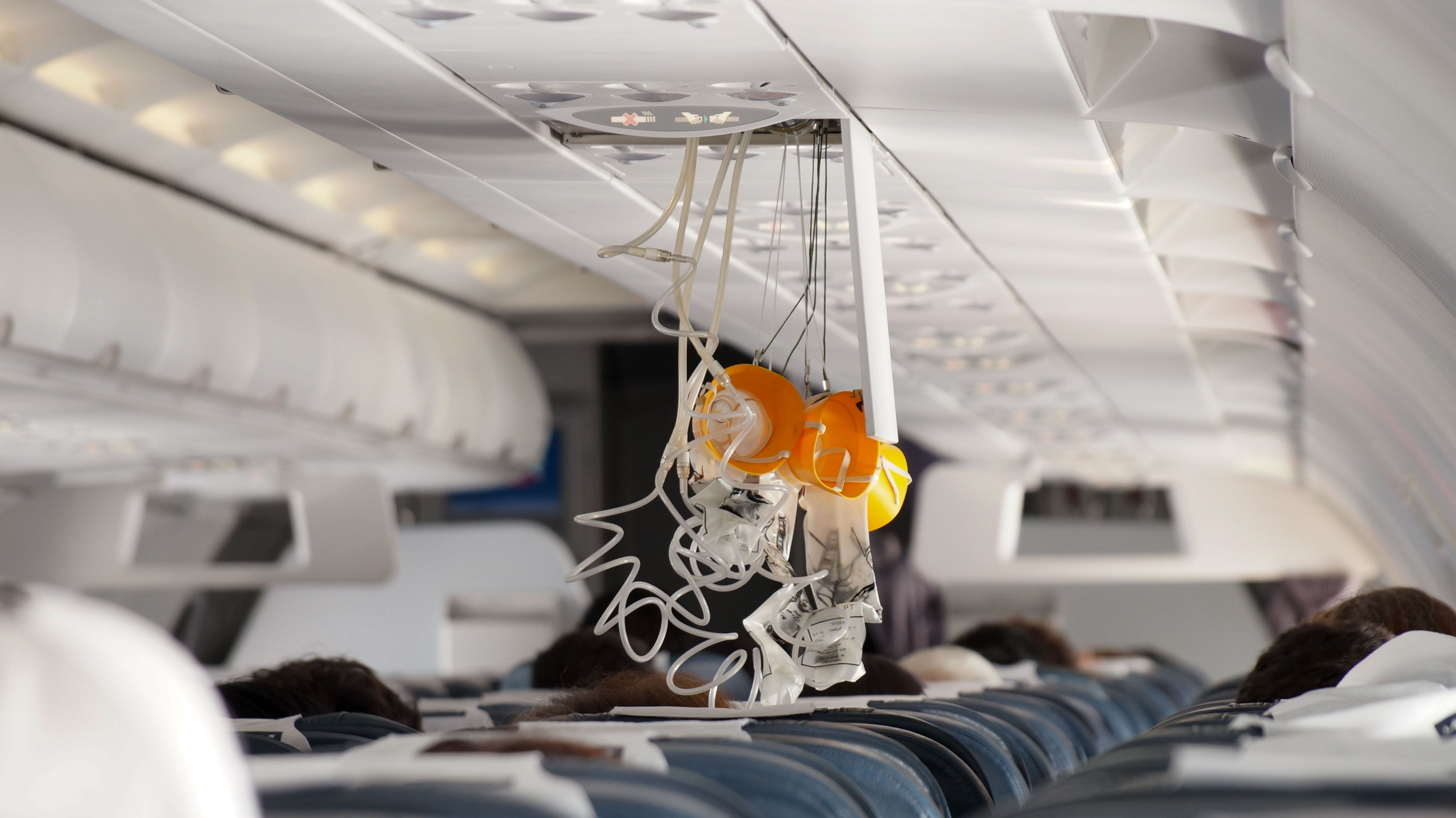 Oxygen masks dropped from the panel above several passengers' heads.