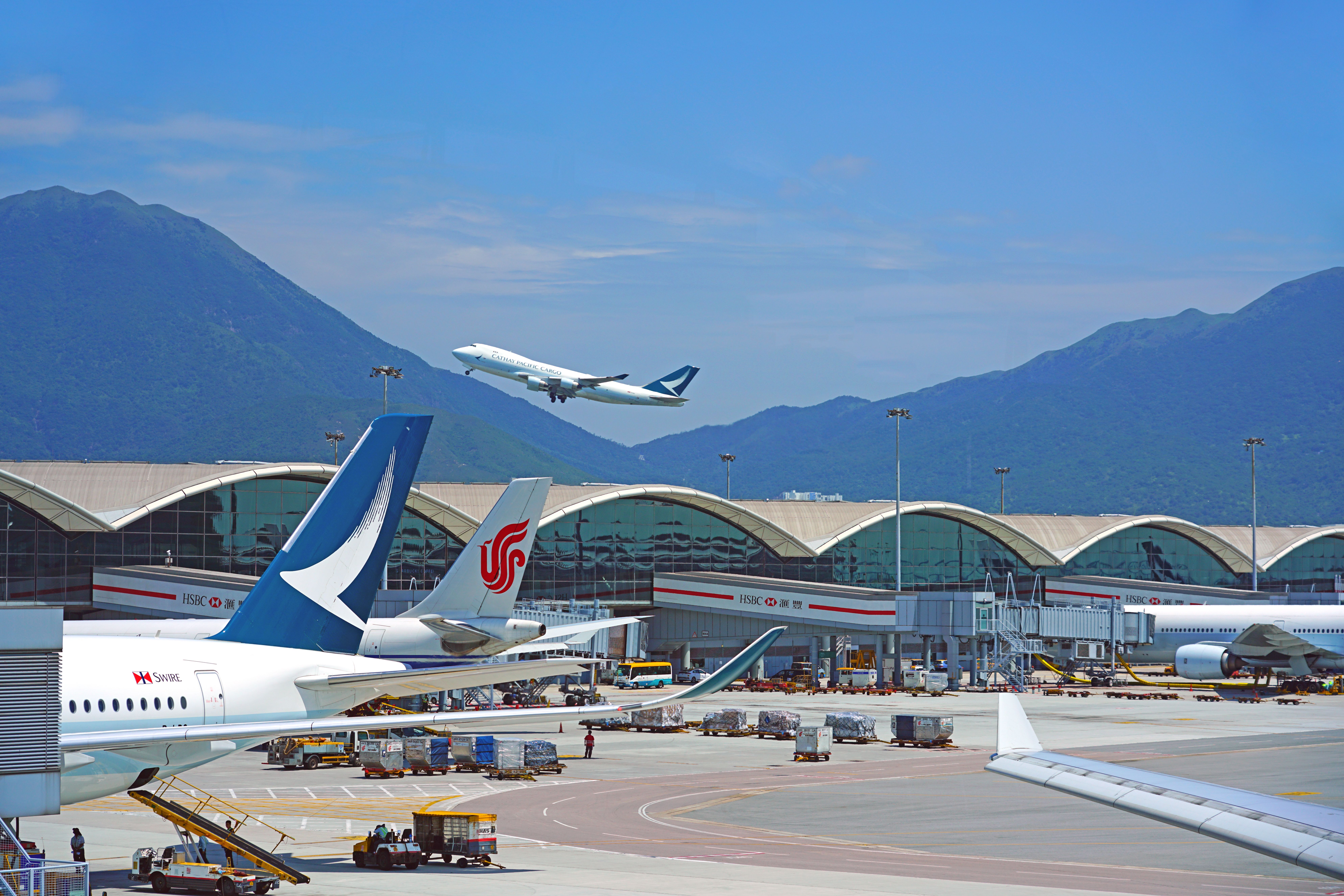 Many aircraft parked at gates at Hong Kong International Airport.