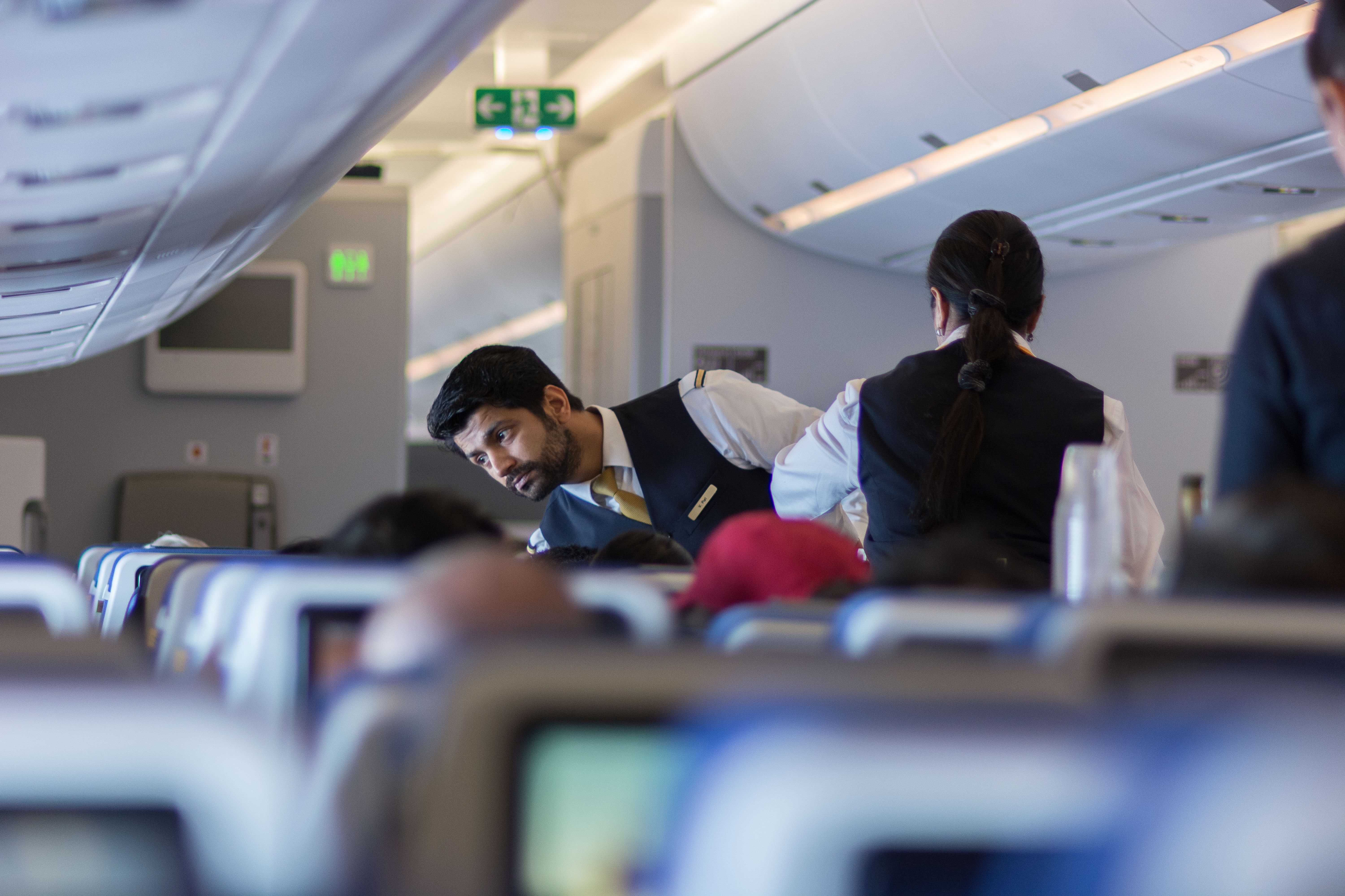 Lufthansa flight attendant speaking with a passenger.