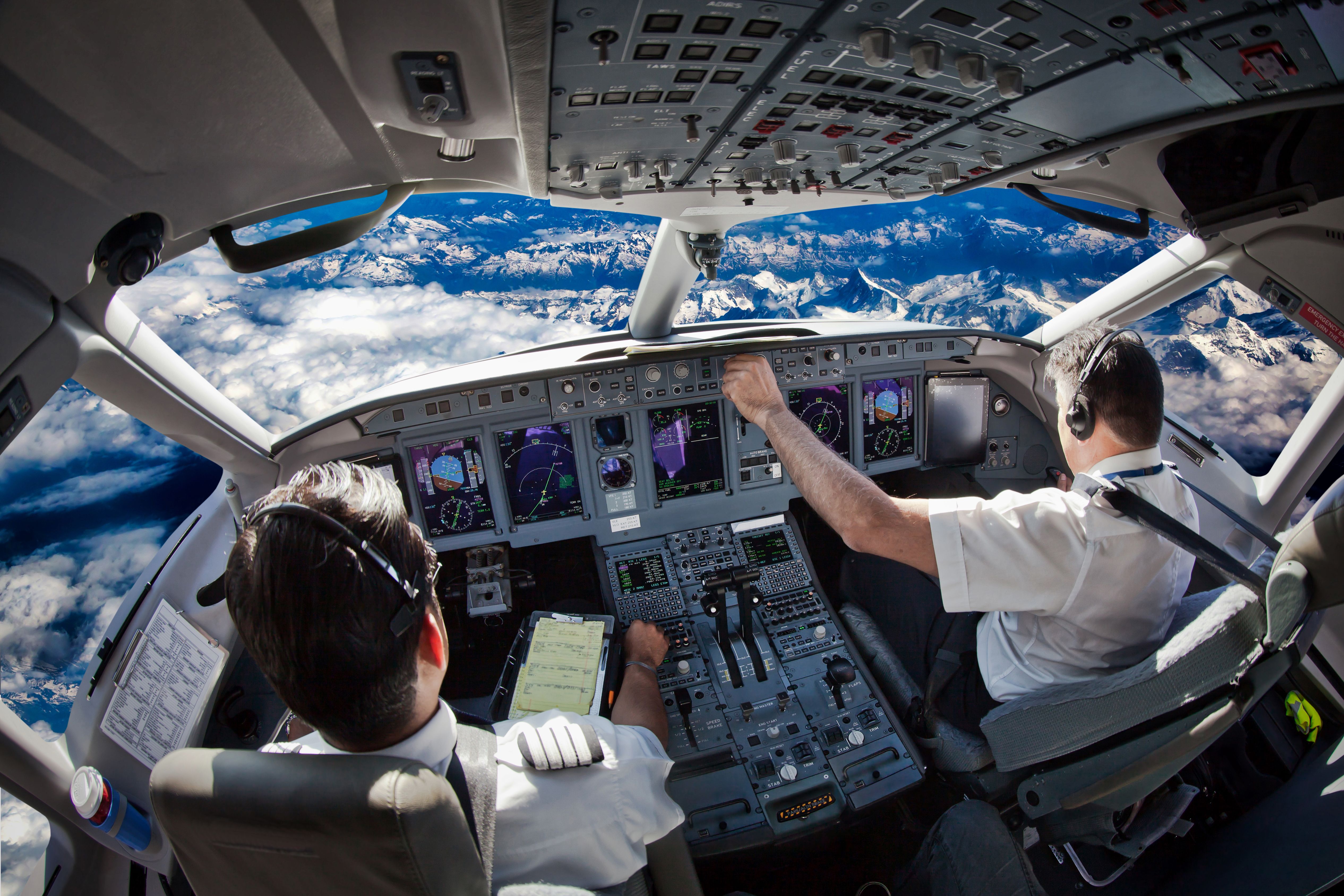 Two pilots working in an airplane cockpit.