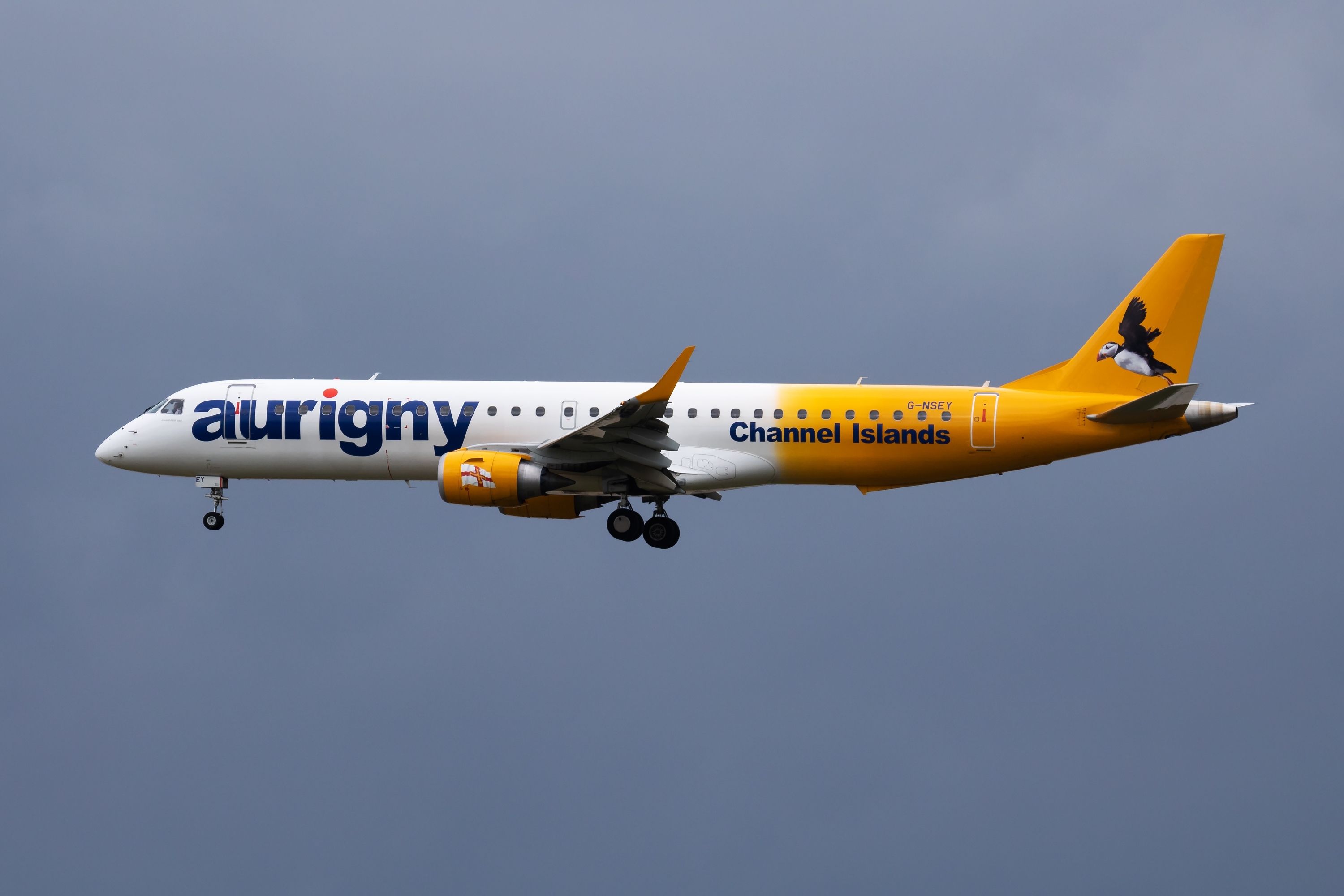 Aurigny Air's Embraer jet, flying below the clouds.