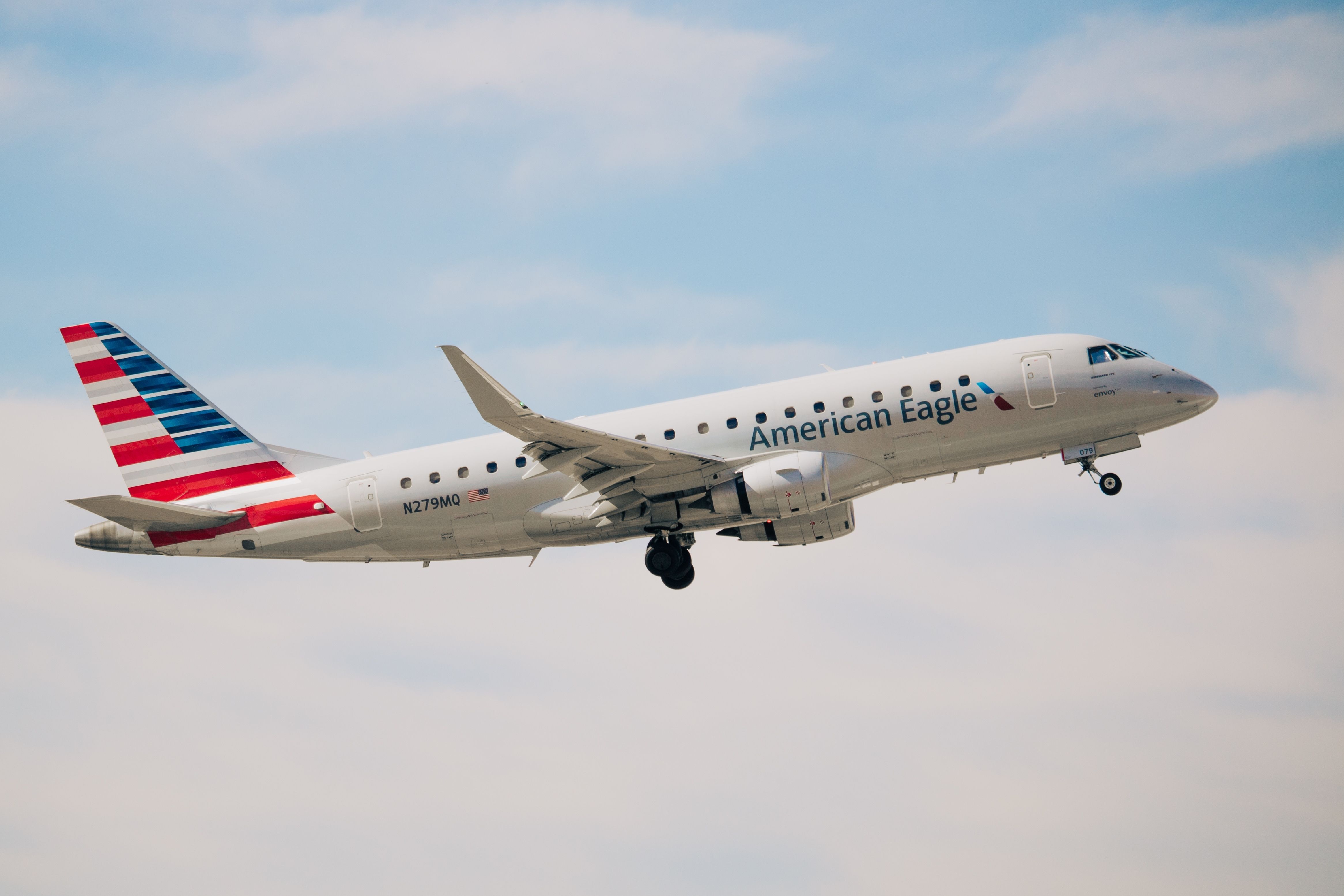 An American Eagle Embraer E170 flying in the sky.