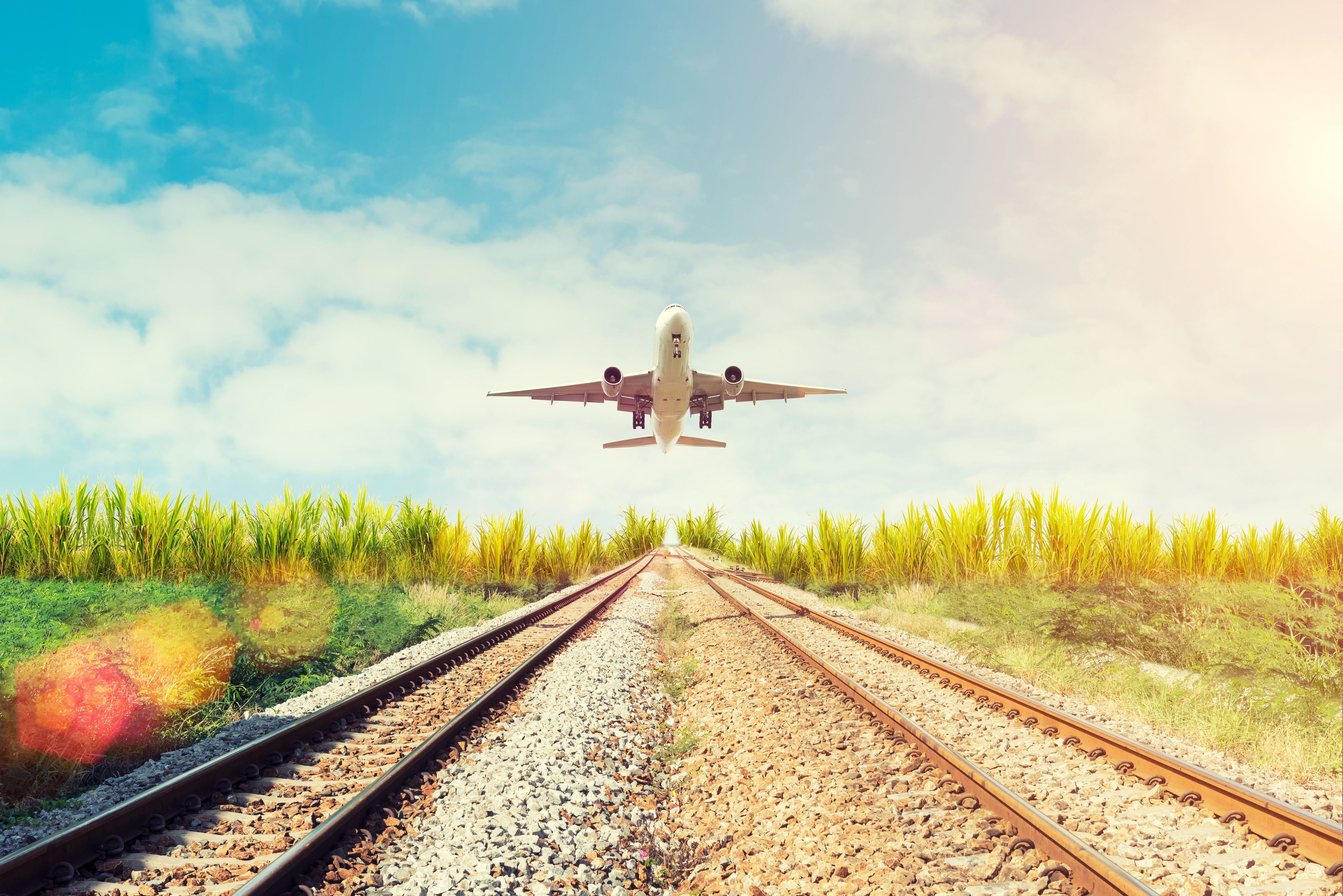 Airplane Taking Off Over Railway