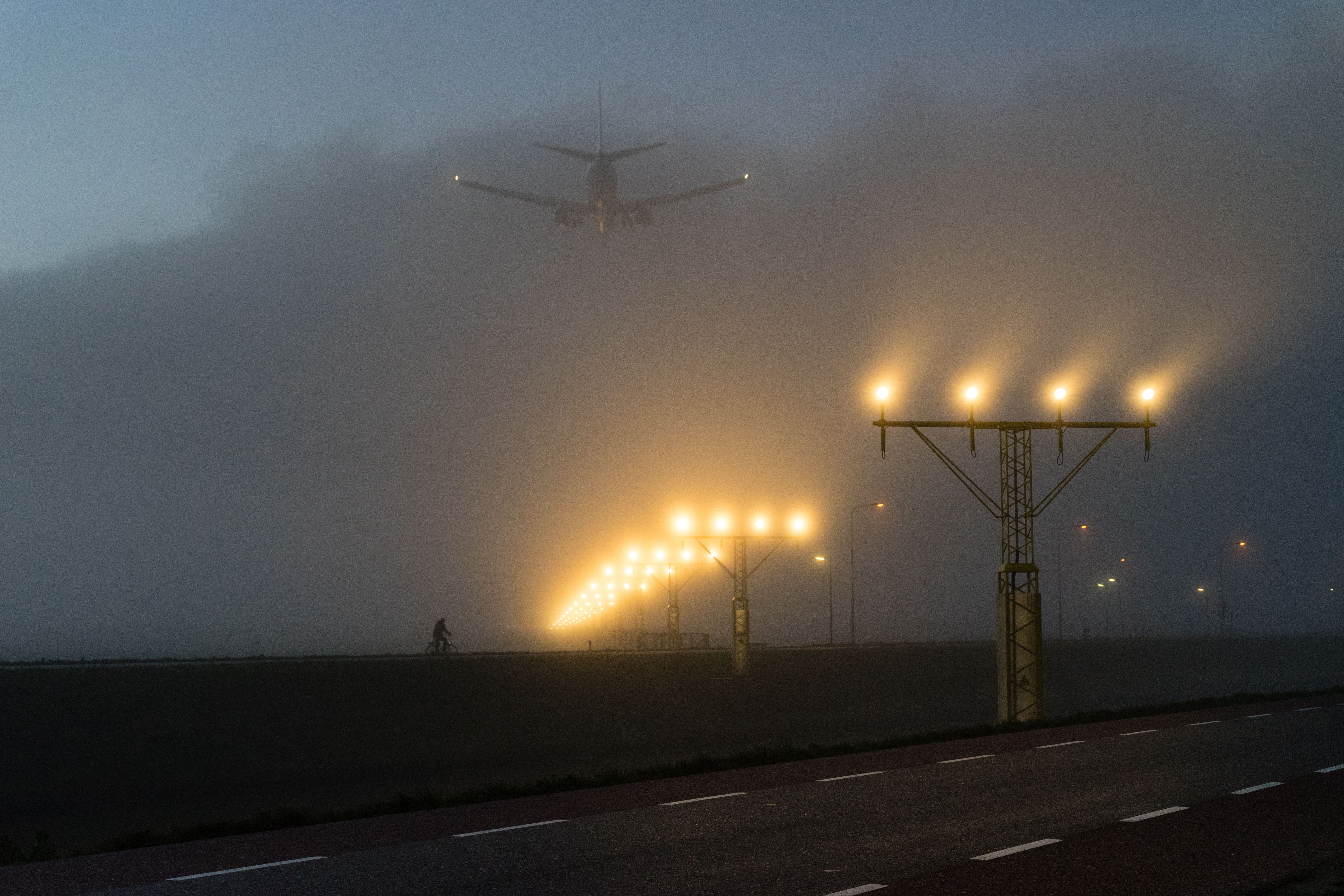 A plane landing in foggy conditions.