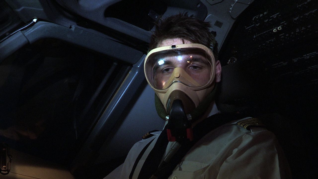 A pilot wearing a full oxygen mask.