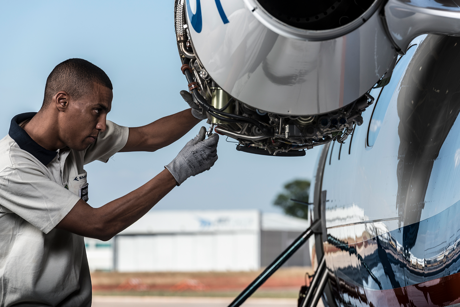 An Embraer maintenance engineer works on an engine. 