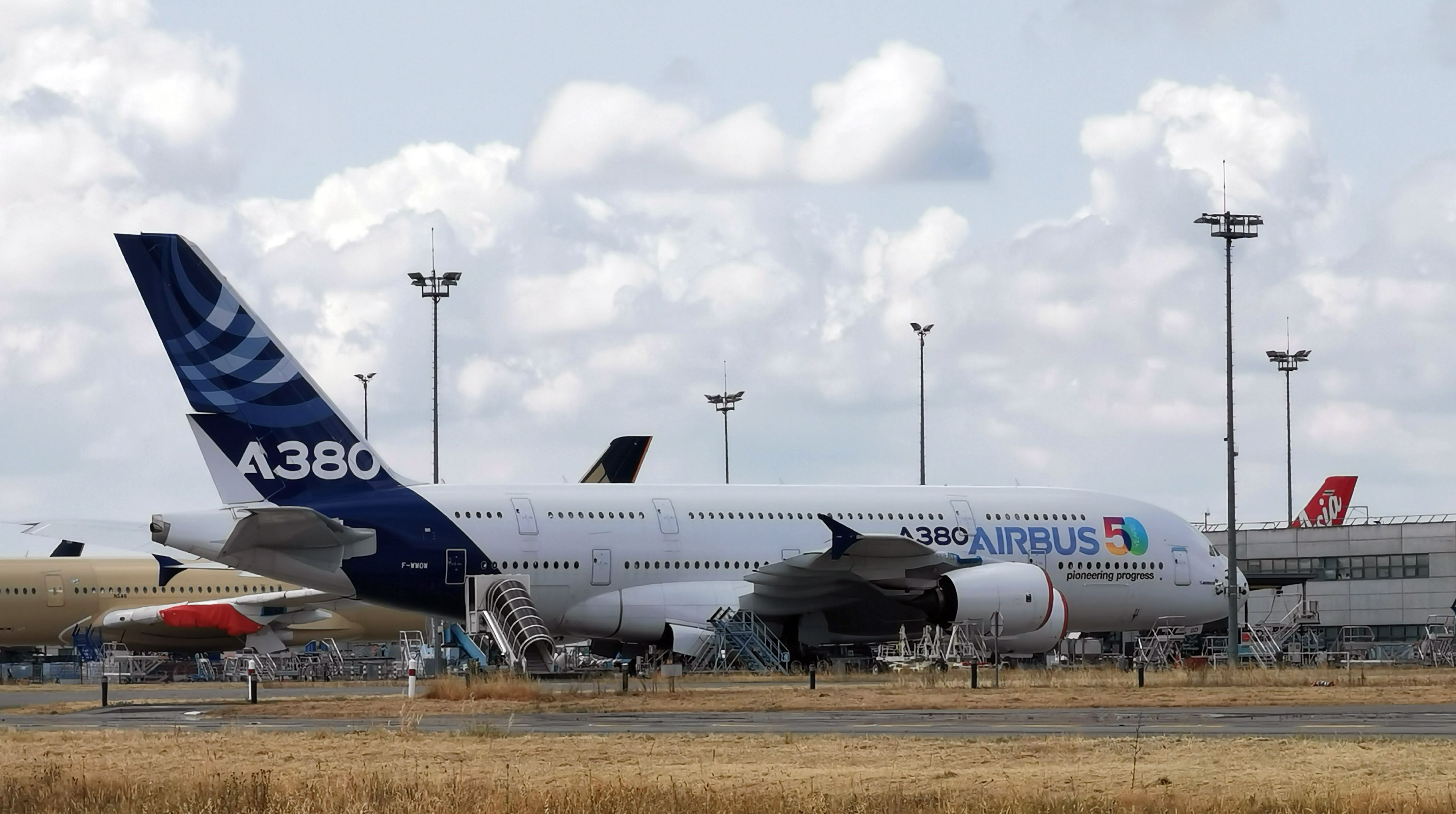 An Airbus A380 in house livery parked at an airport.