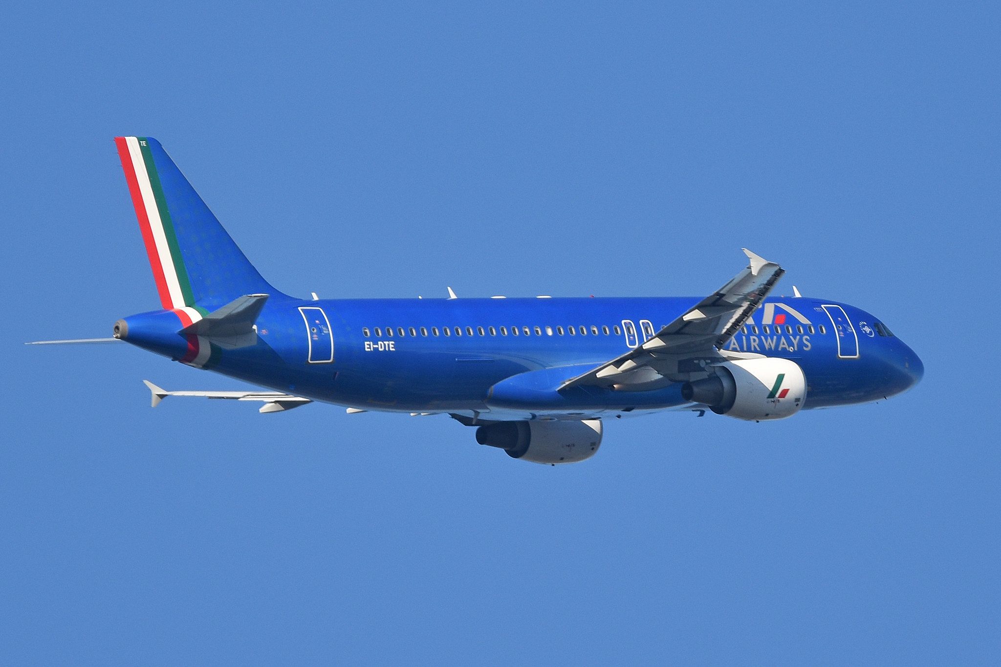 An ITA Airways Airbus A320-200 flying in the sky.