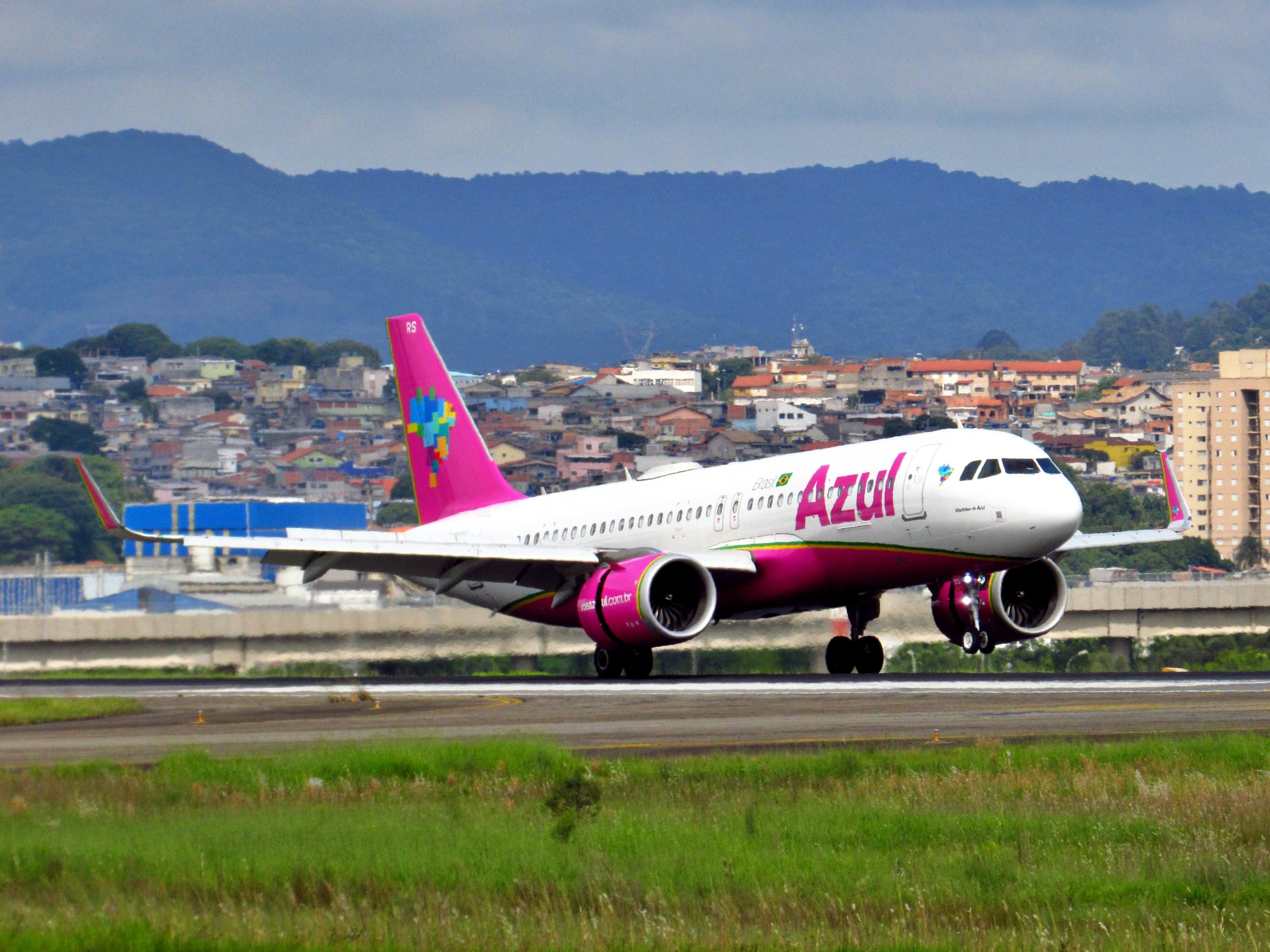 An Azul Airbus A320 in a pink livery taking off.