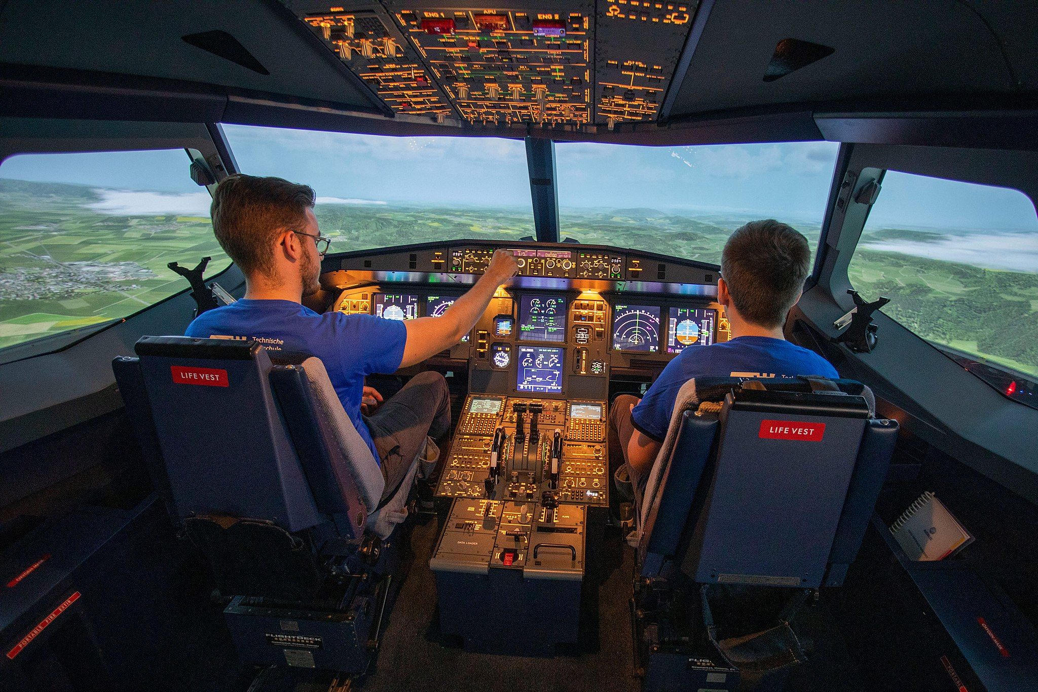 A pilot and student inside an A320 simulator. 