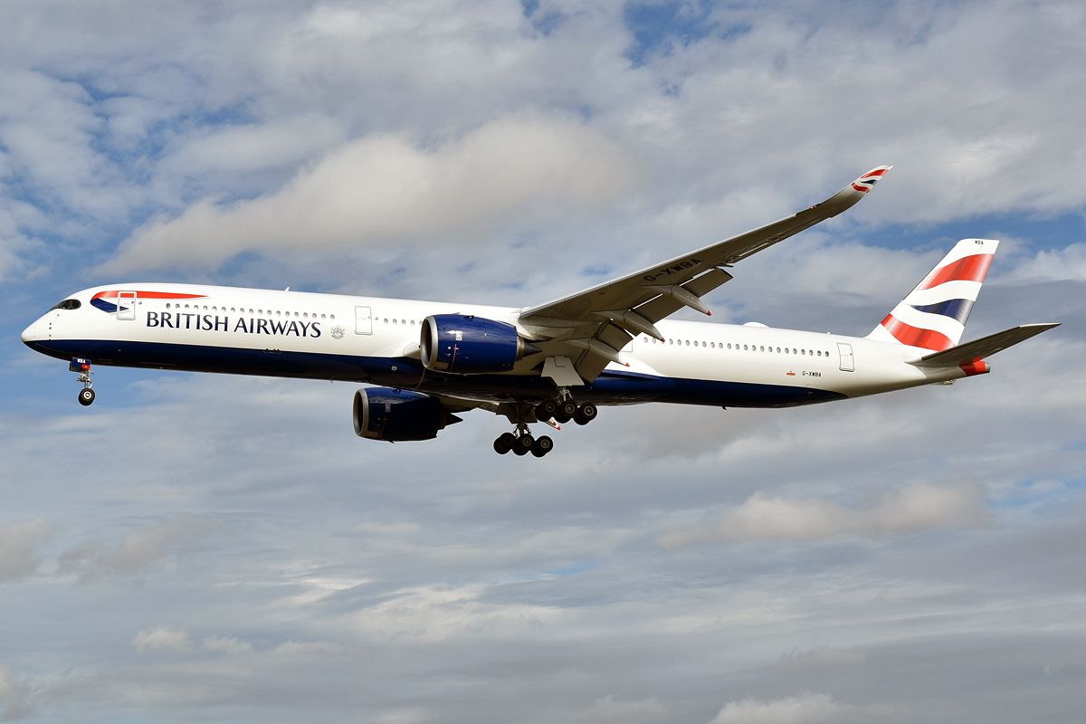 A British Airways Airbus A350-1041, registration G-XWBA, flying below the clouds.
