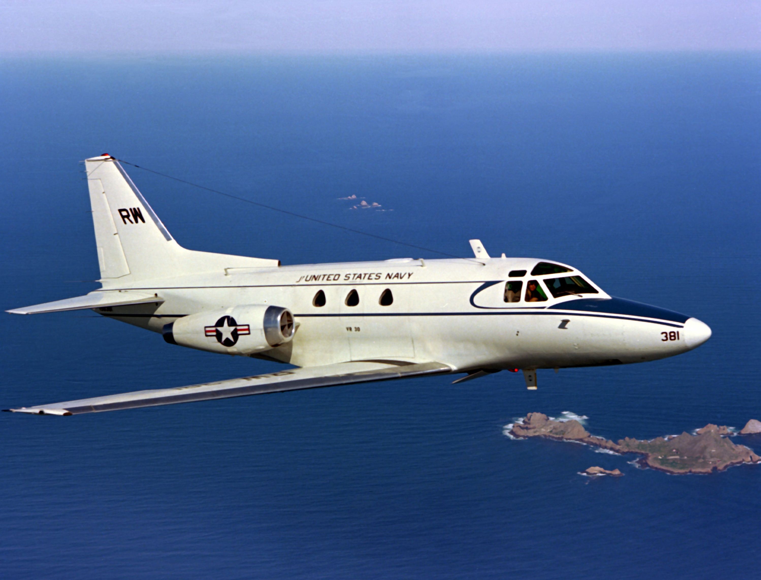 A CT-39E Sabreliner in flight over some islands.