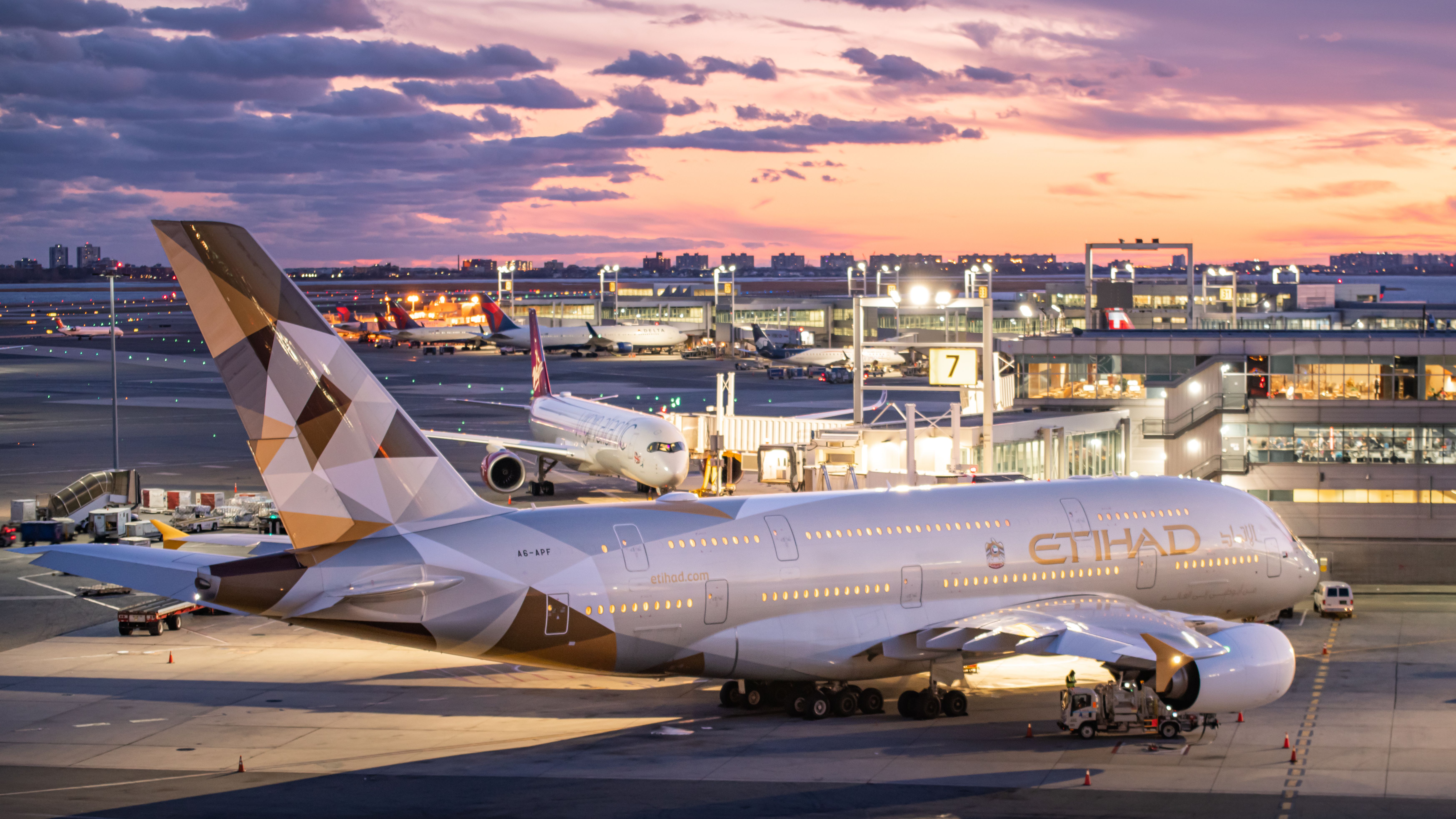 An Etihad Airbus A380-861, registration A6-APF, pulling up to an airport stand.