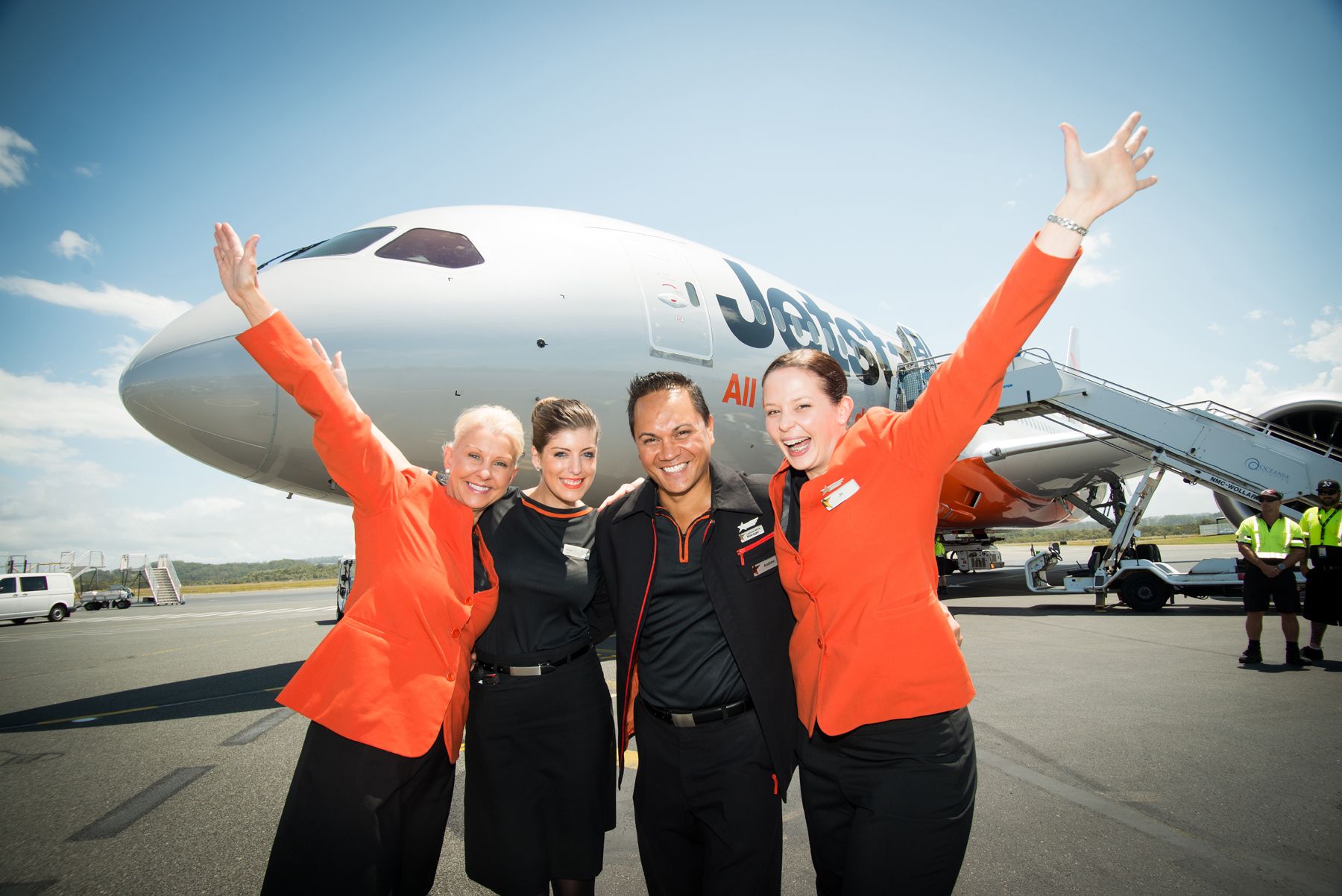 Jetstar cabin crew standing outside a parked aircraft.