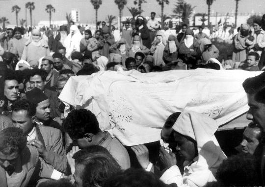 Touria Chaoui being carried by many inside of a casket.