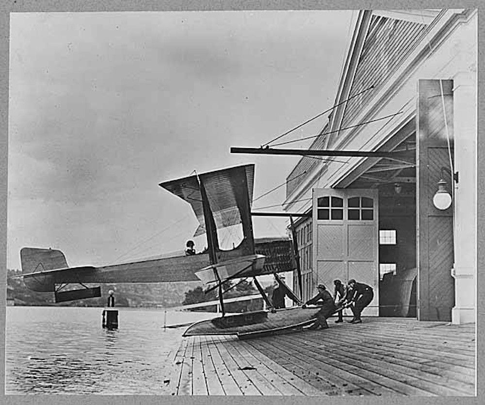 Men pulling a B & W Seaplane into the Boeing Seaplane Hangar on Lake Union, Seattle.