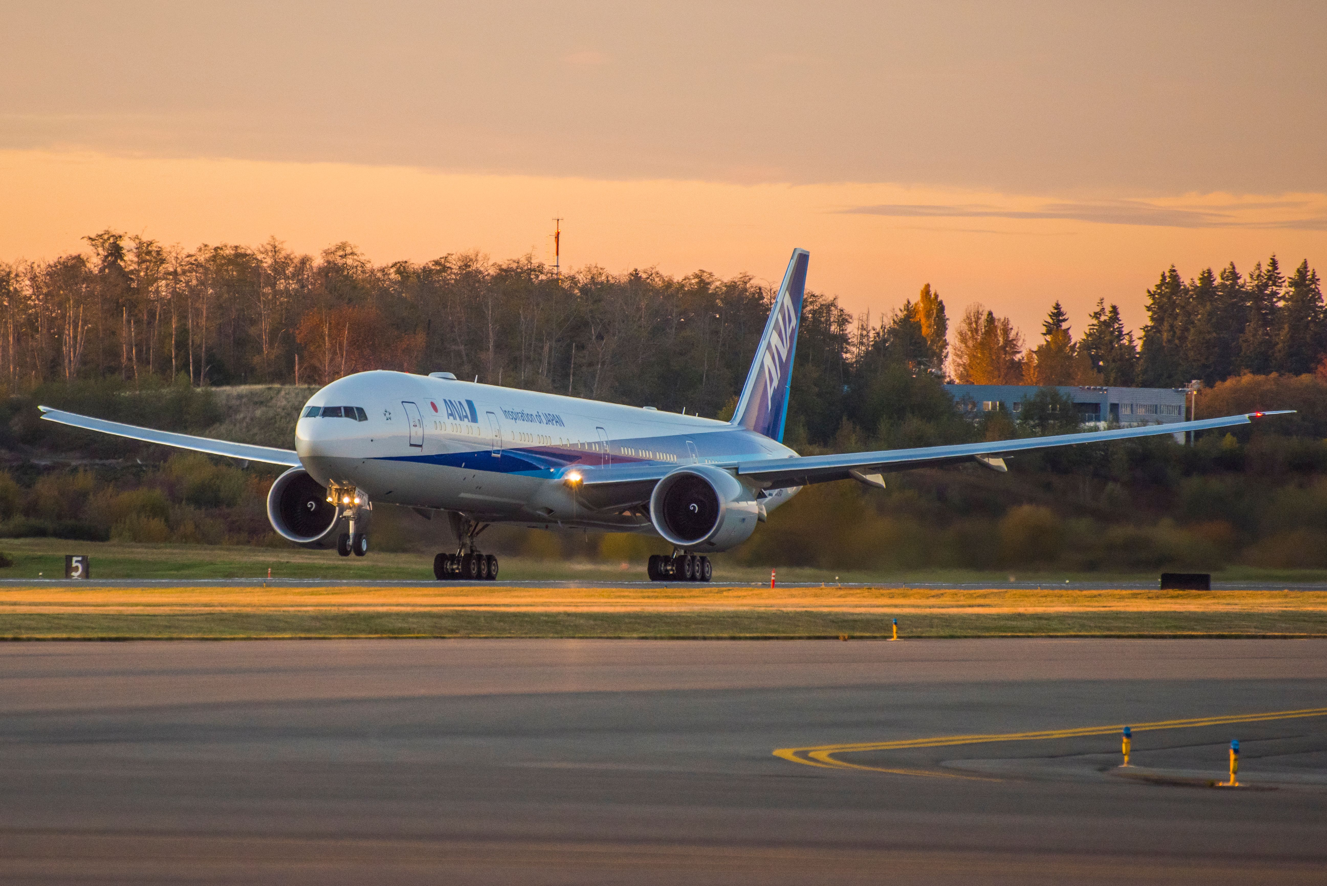 An ANA Boeing 777 rolling fast down the runway.