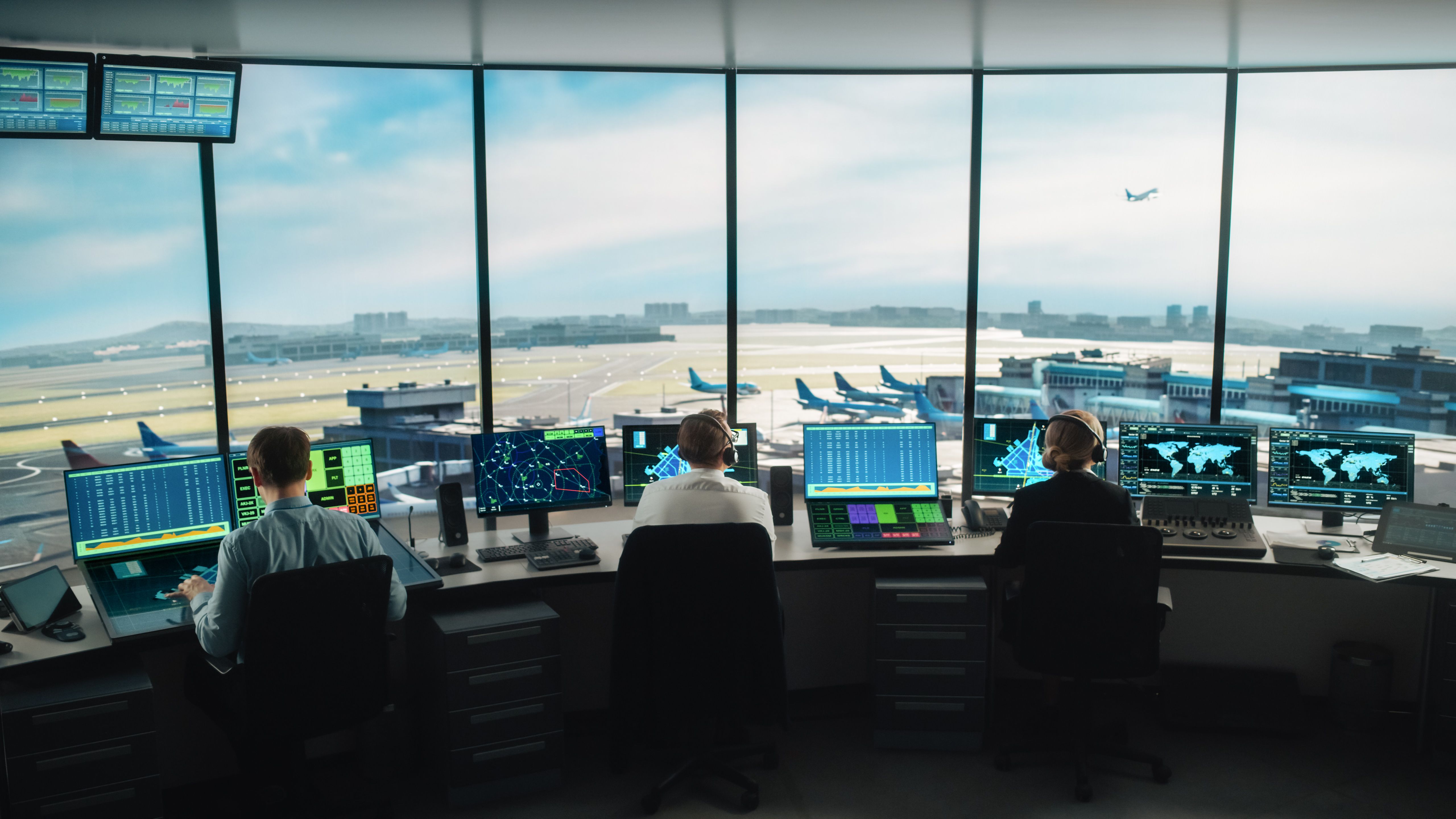 Several air traffic controllers at their workstations.