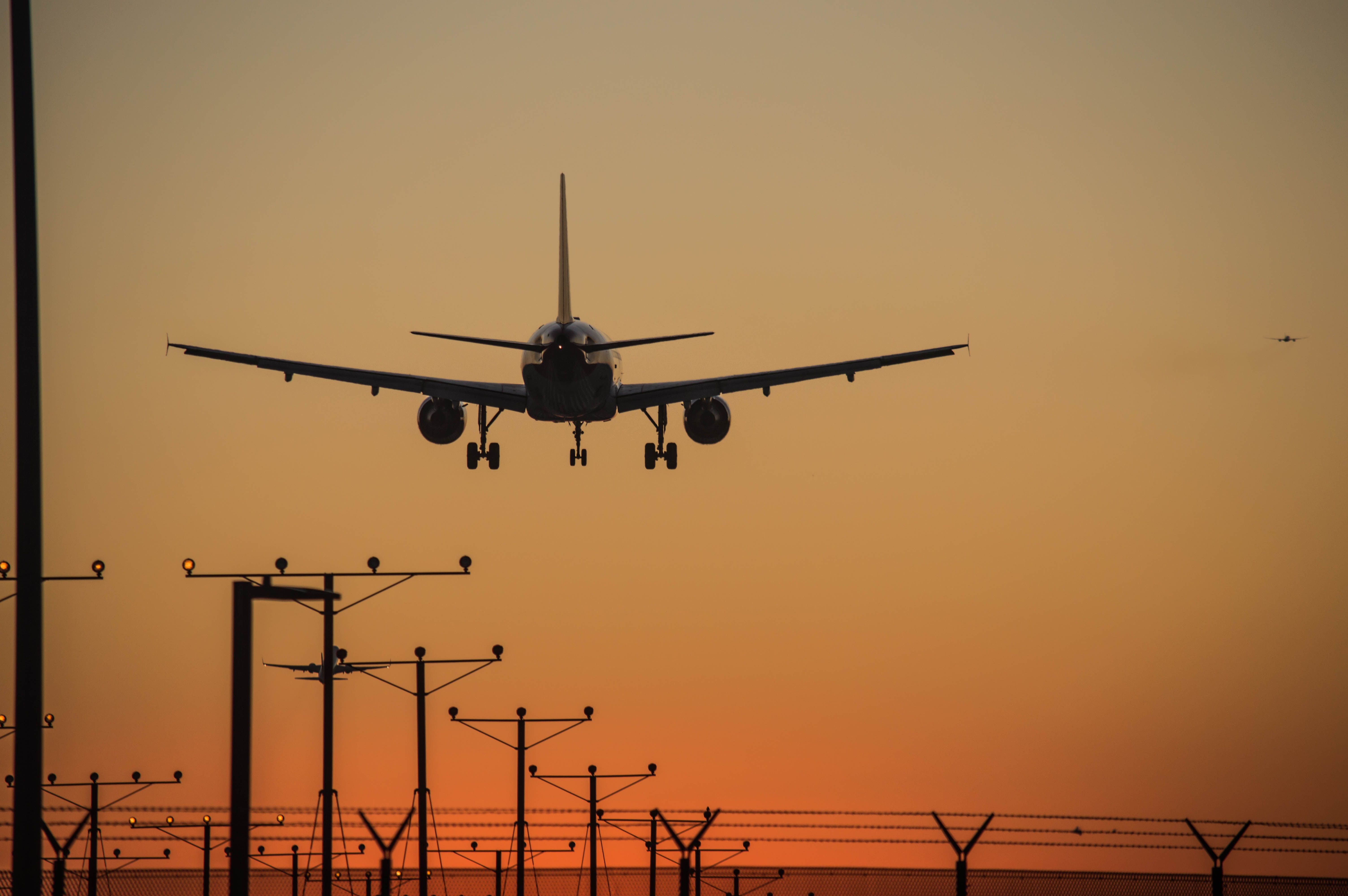 Aircraft landing at Los Angeles International Airport during sunset