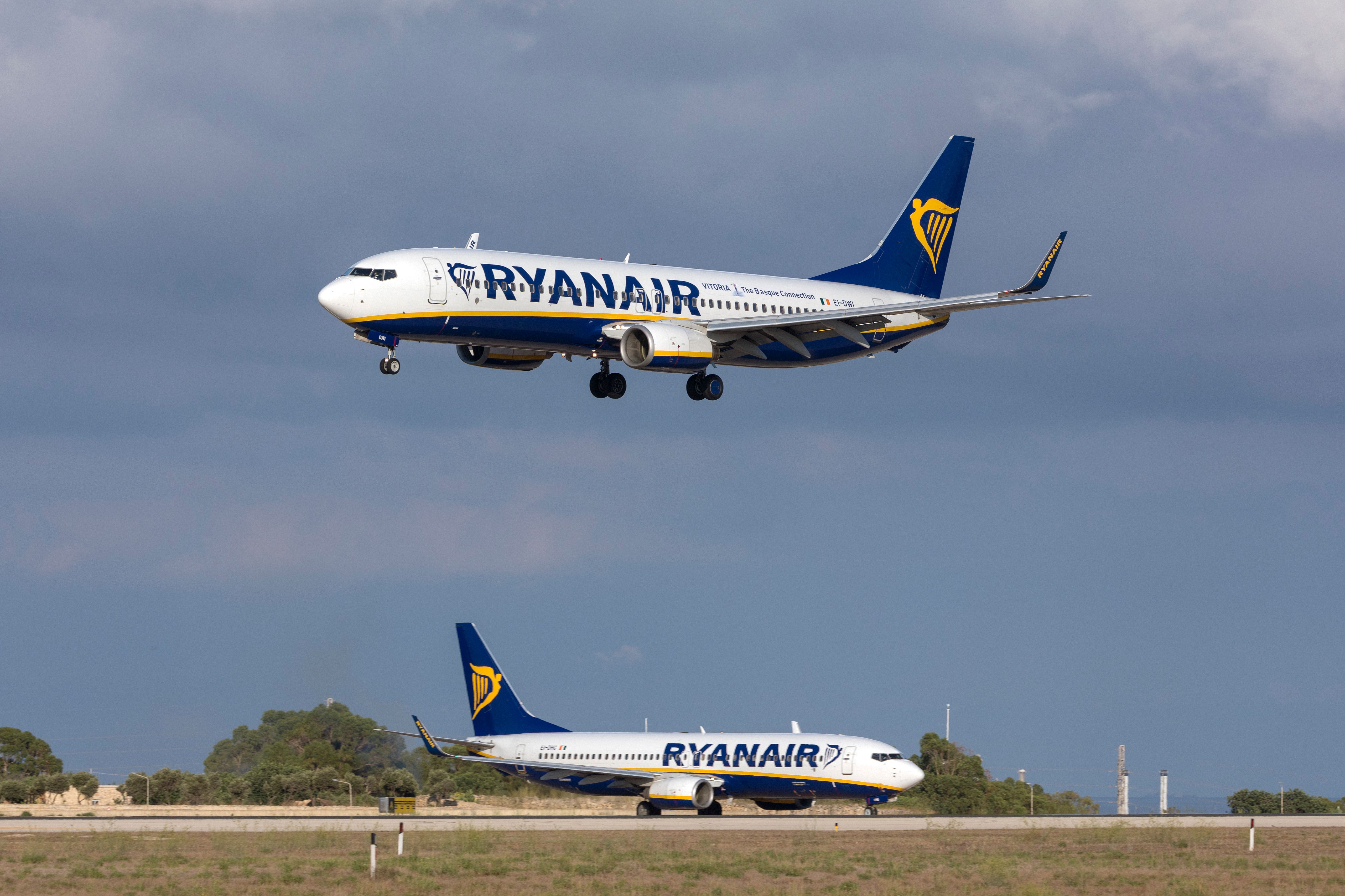 A Ryanair Boeing 737 about to land as another waits to take off.