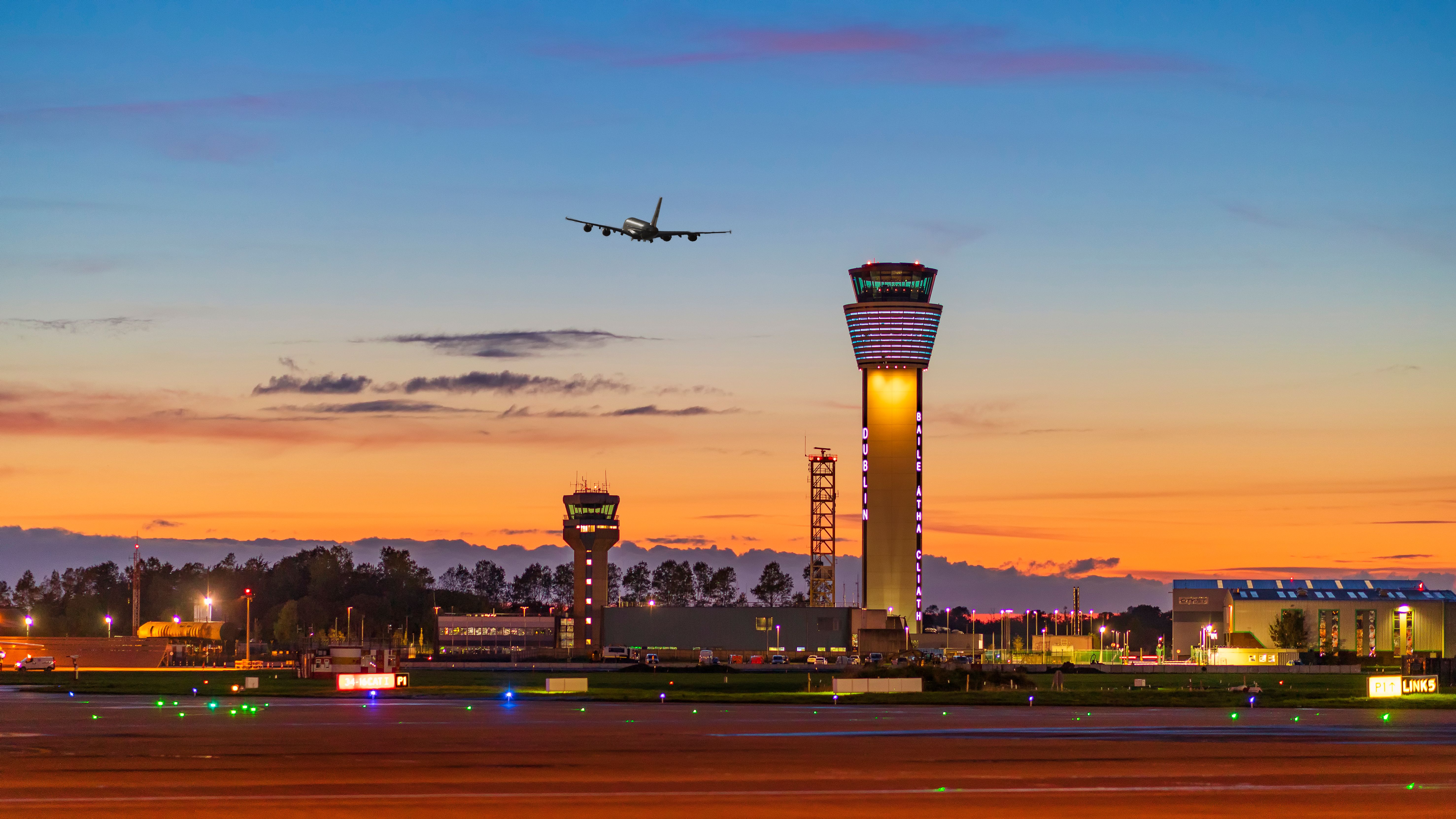 A panoramic photo of Dublin Airport, including its ATC Tower, at Sunset.