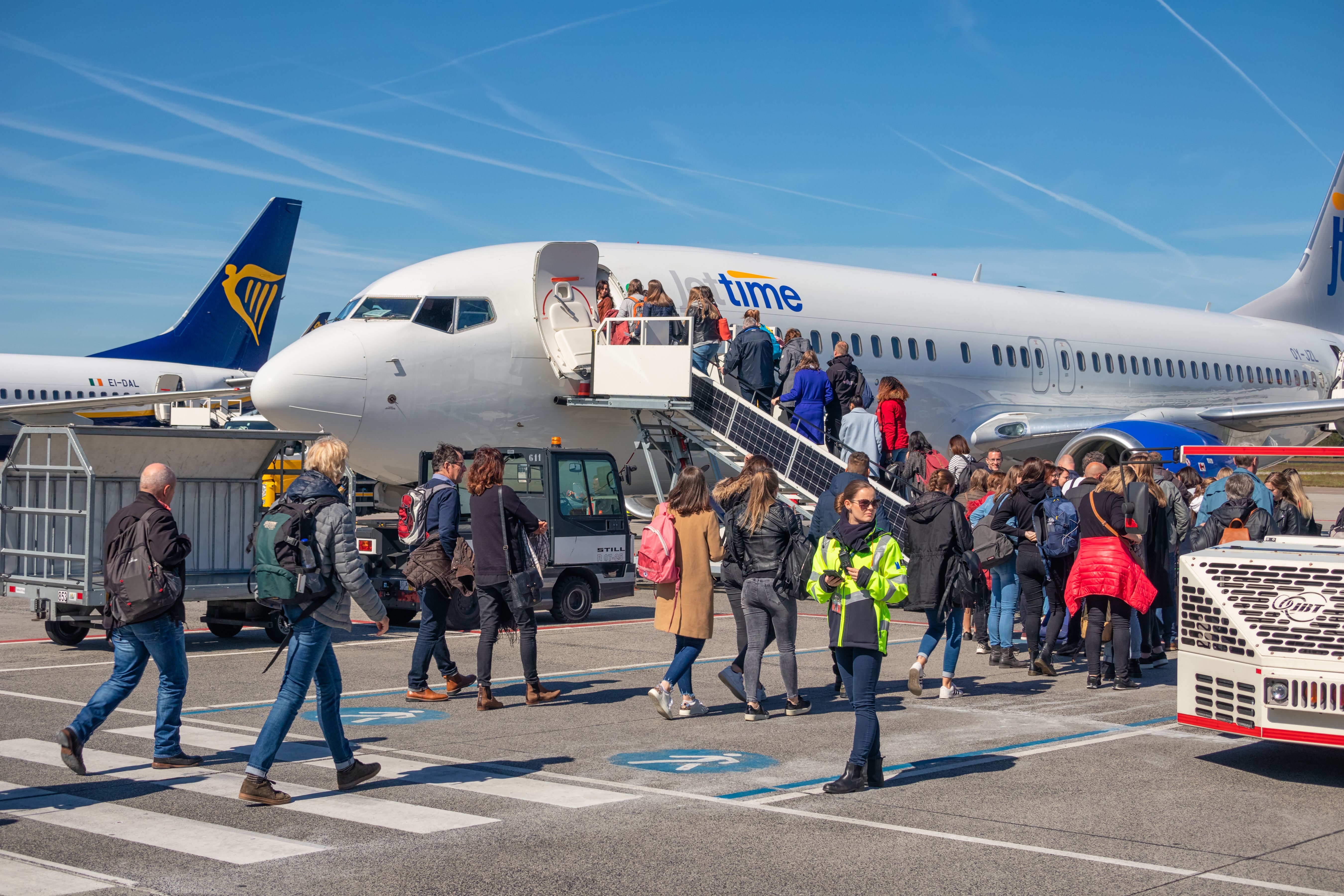 Travelers entering an airplane ready for departure at Eindhoven airport.