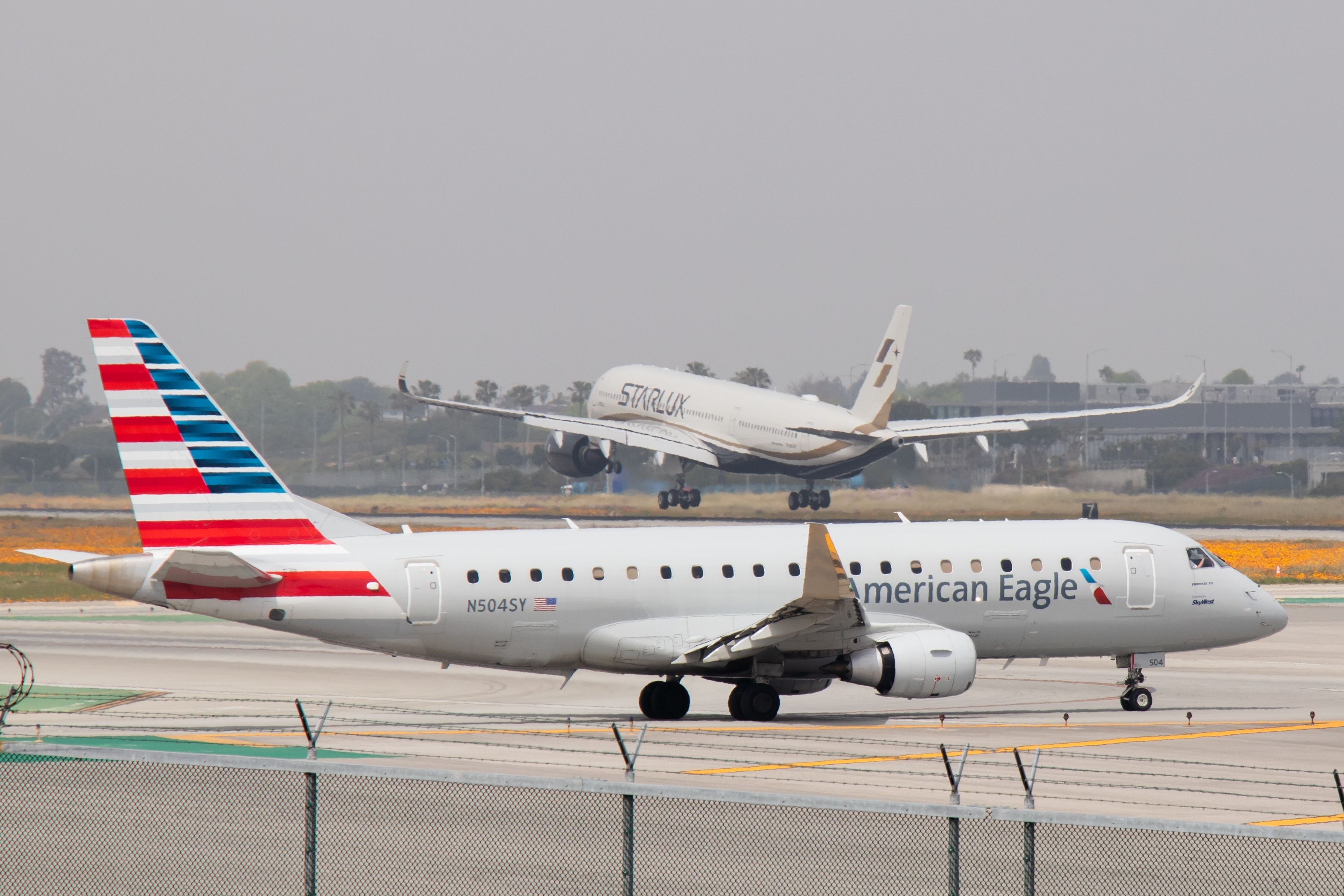 An American Eagle Embraer 175 holding for A Starlux A350 to land at LAX.