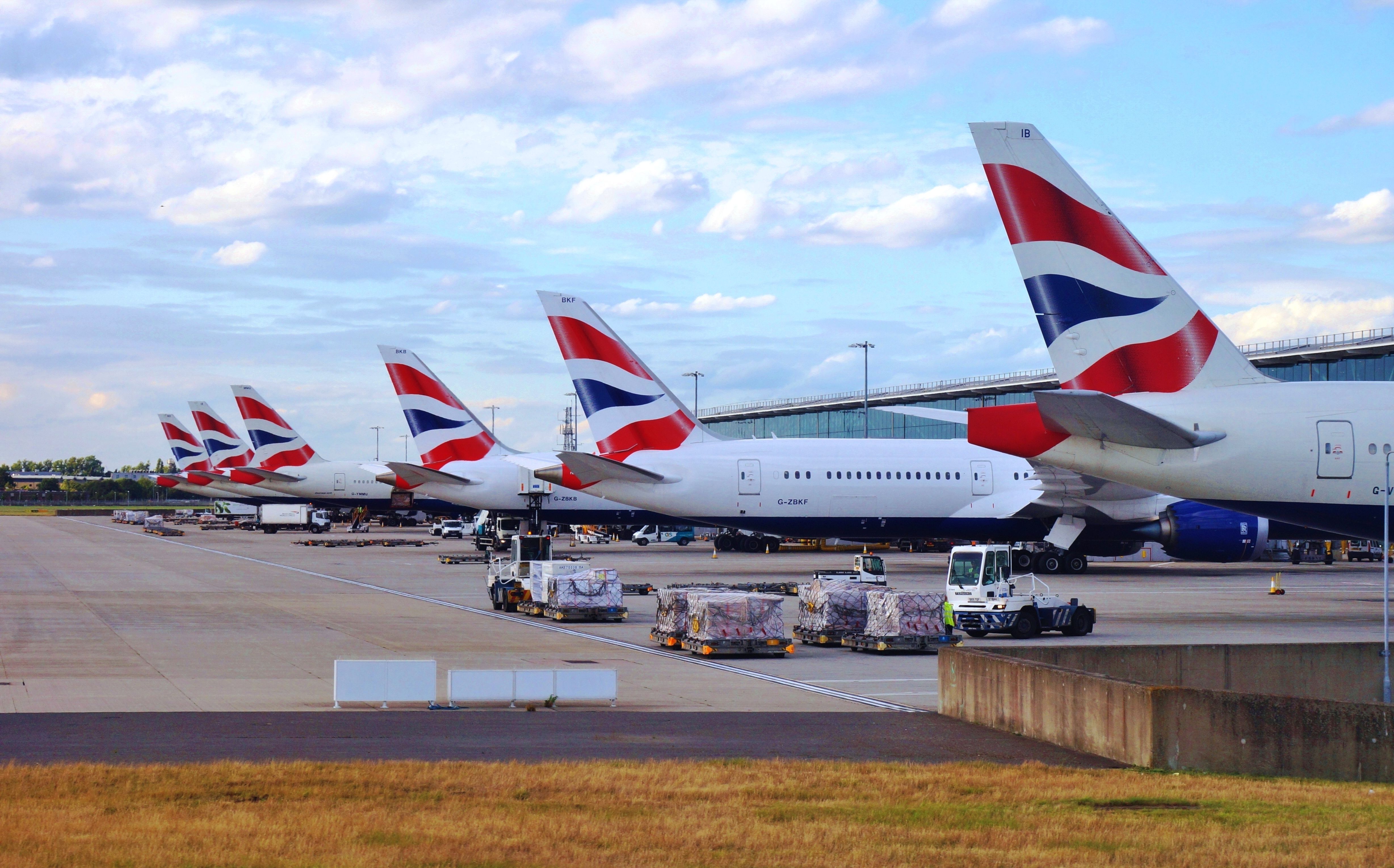 Several British Airways aircraft parked at gates at LHR.
