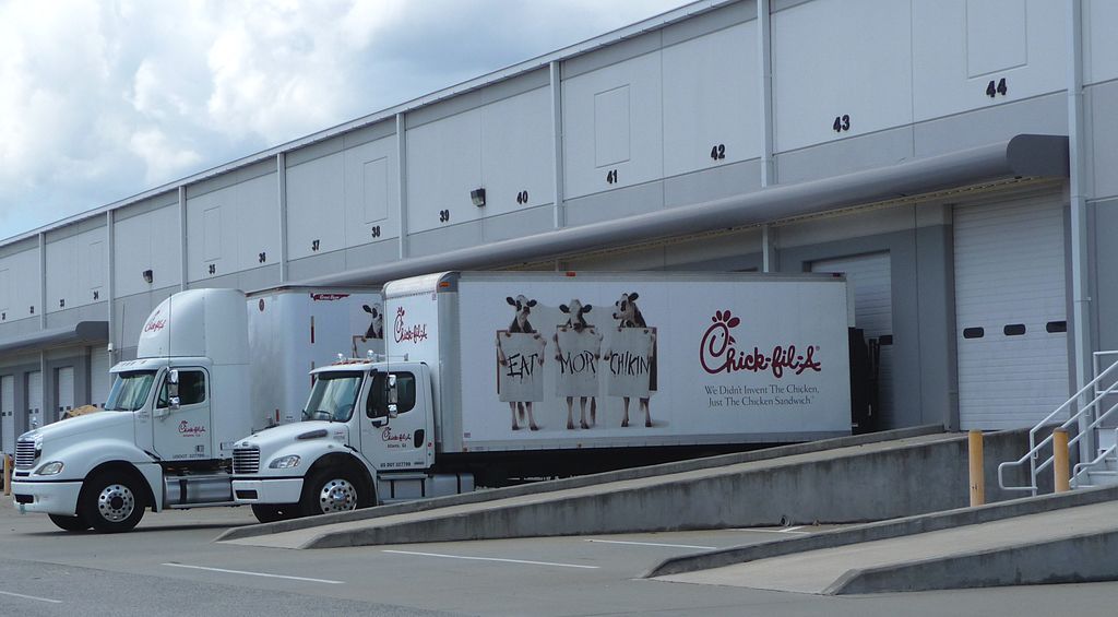 A Chick-fil-A truck making a delivery to an airport.