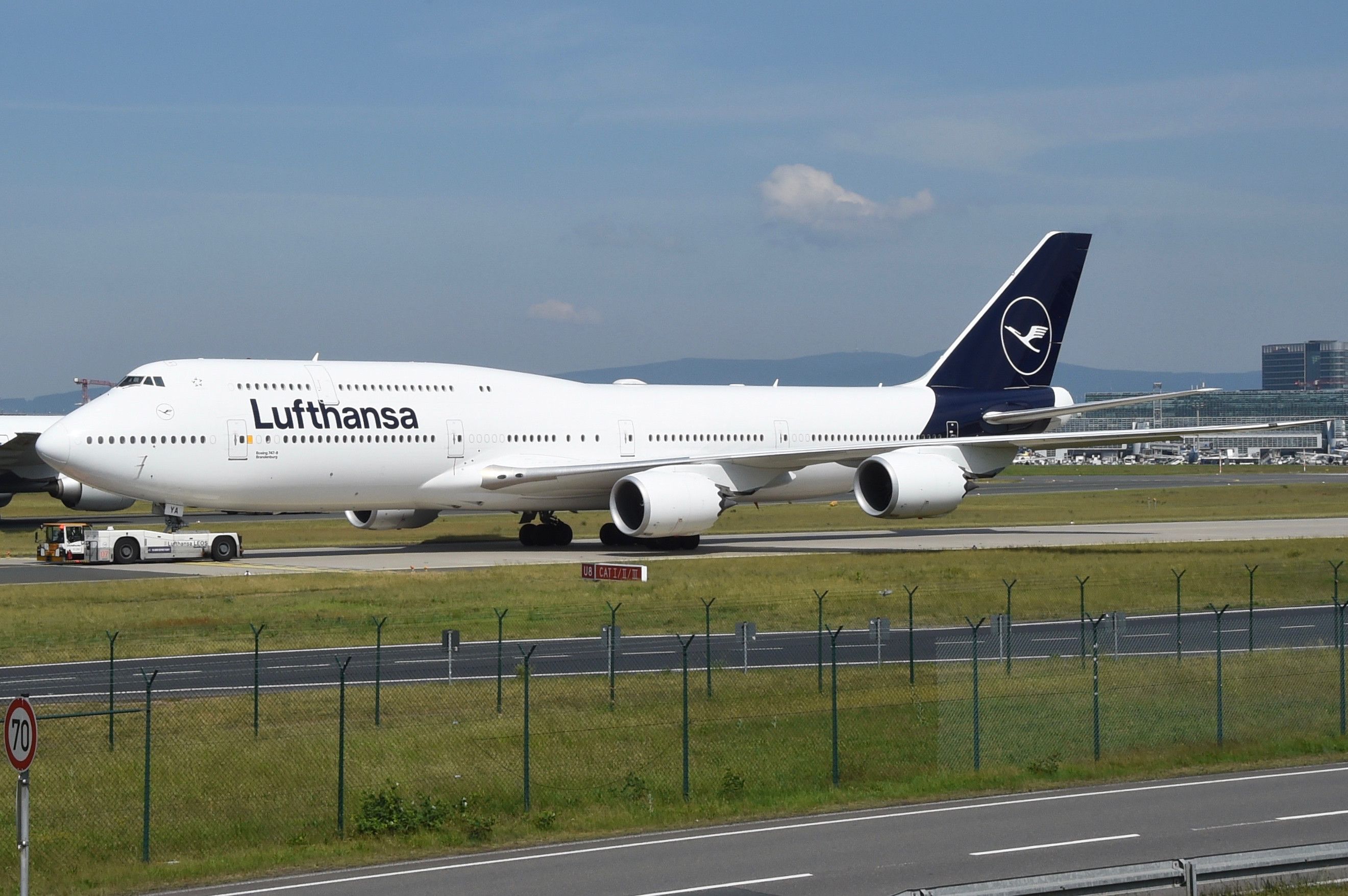 A Lufthansa Boeing 747-800 parked at an airfield.