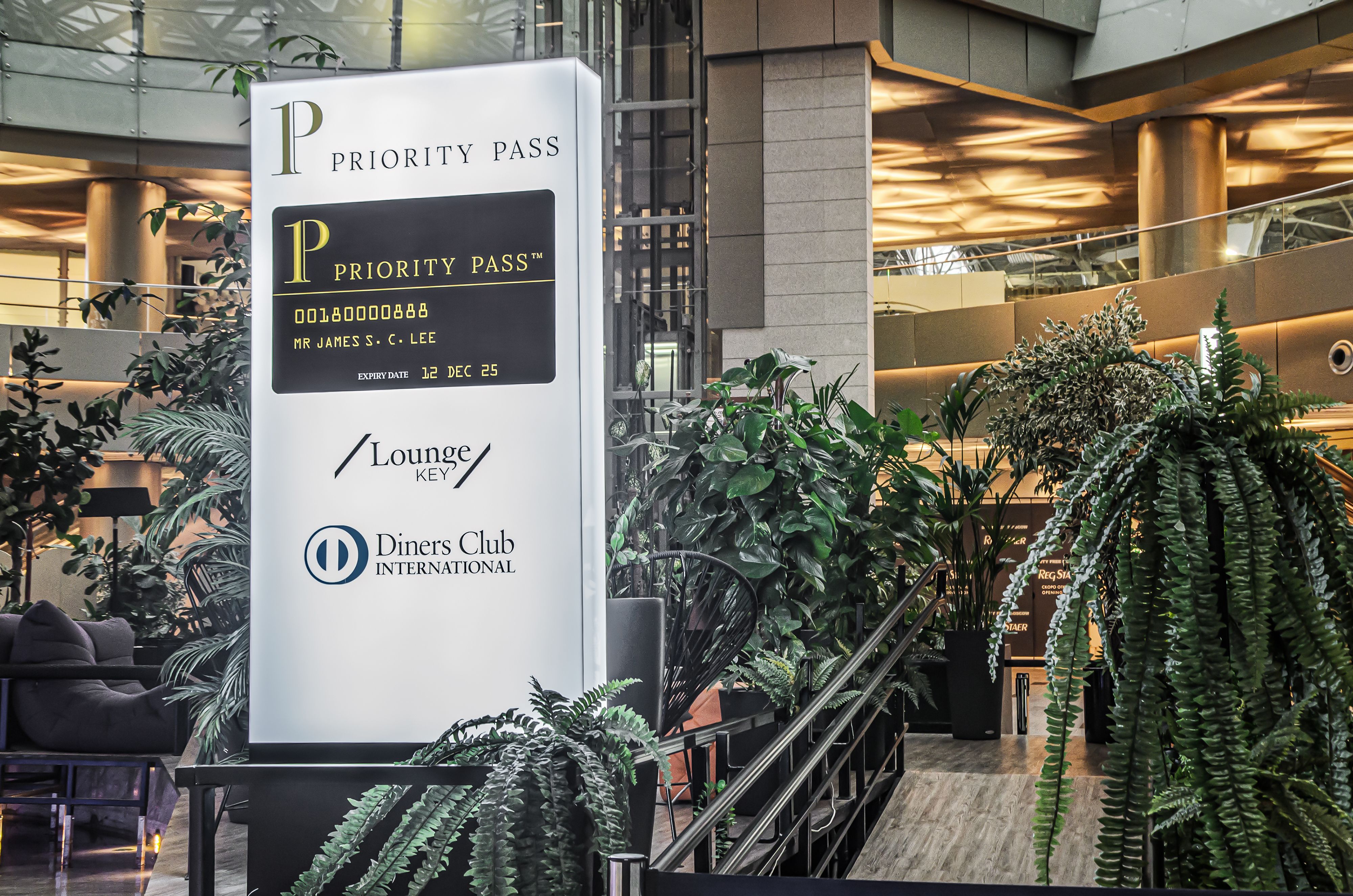 A sign outside of a lounge with the Priority Pass, Diners Club International, and Lounge Key logos.