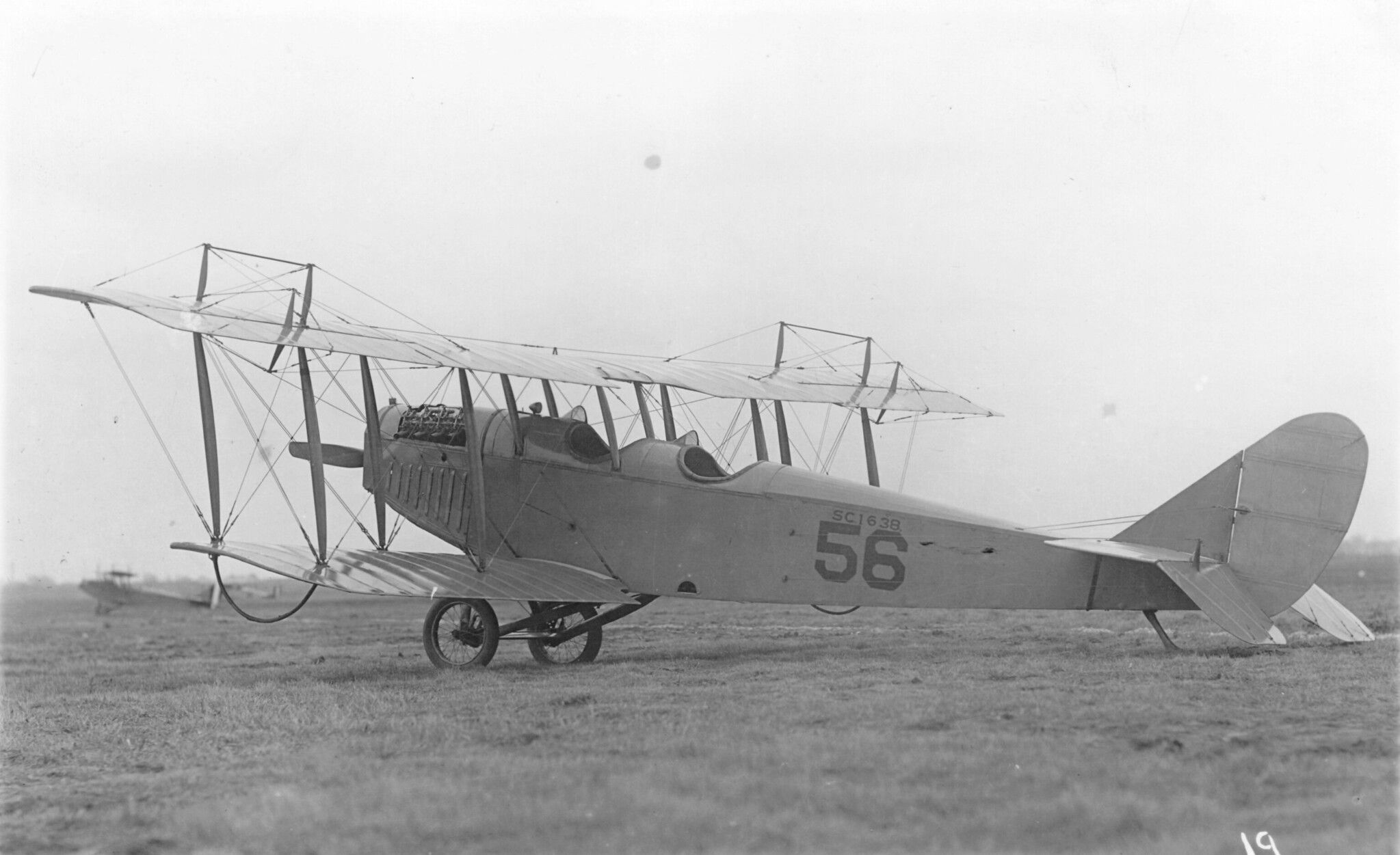 A Curtiss JN-4 Jenny parked in a grass field.