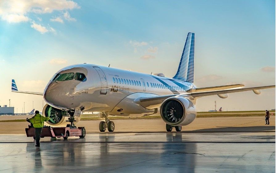 An Airbus A220ACJ being pushed back out of a hangar.