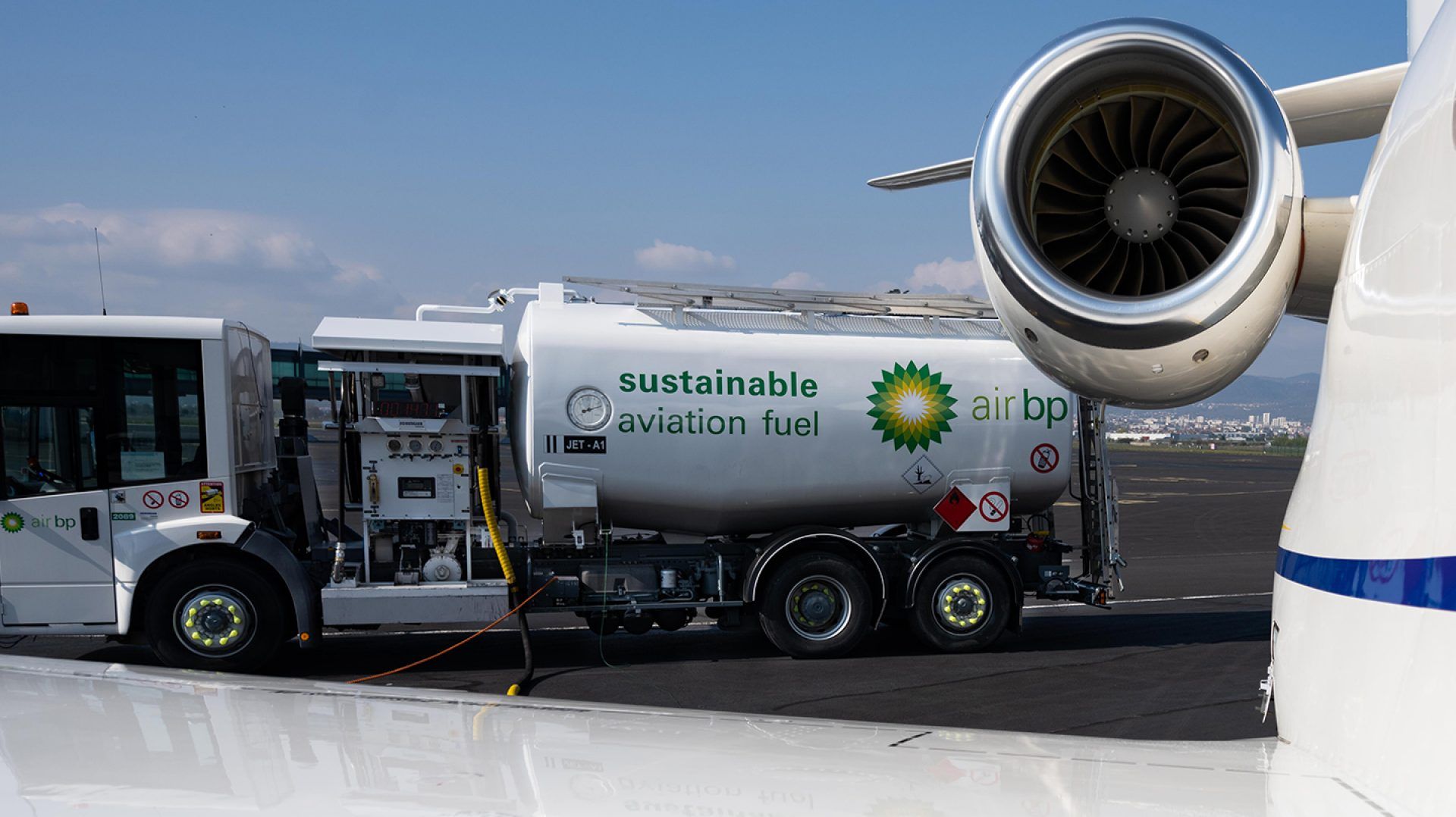 An Air bp Sustainable aviation fuel vehicle next to a small jet aircraft.