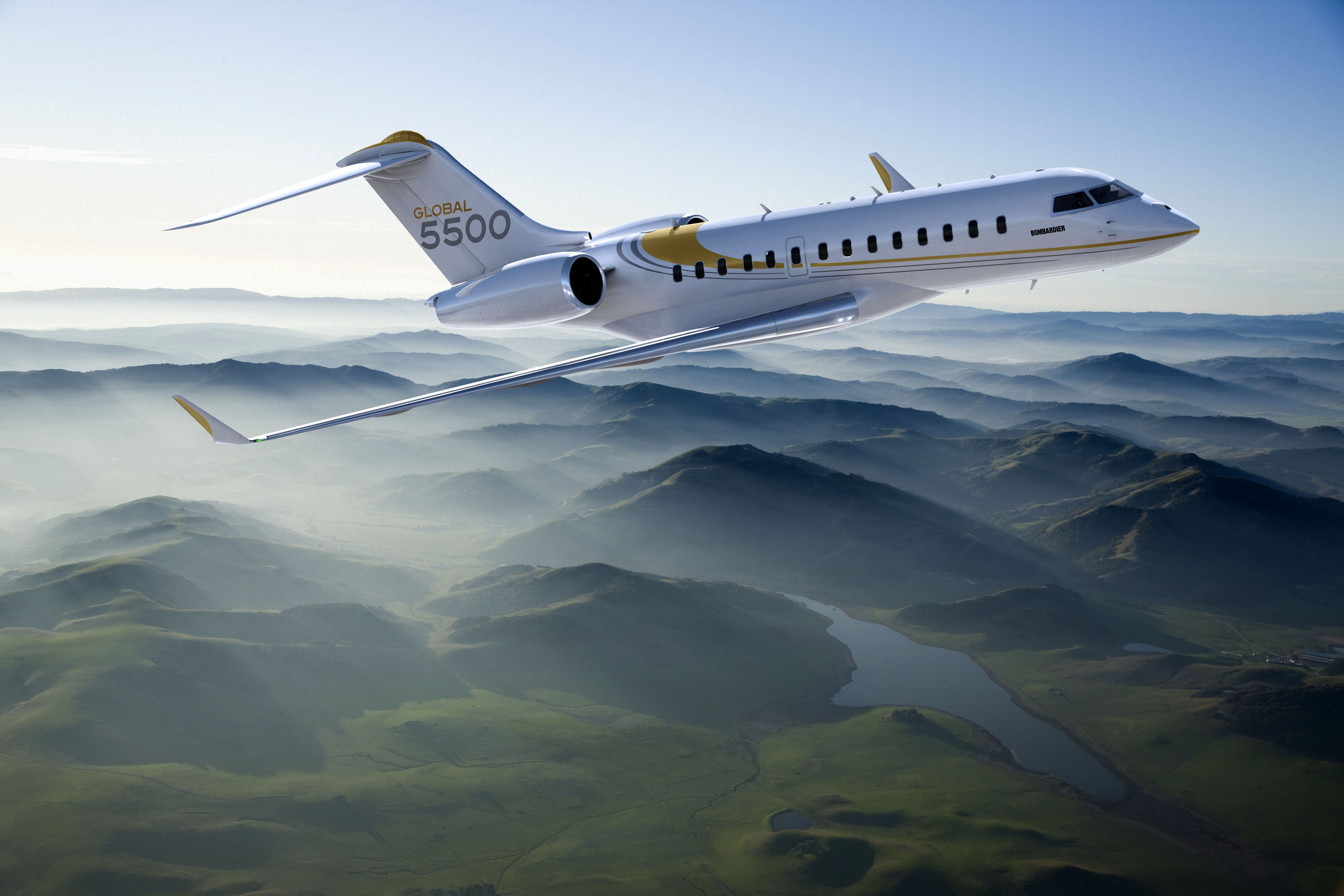 A Bombardier Global 5500 flying above mountains.