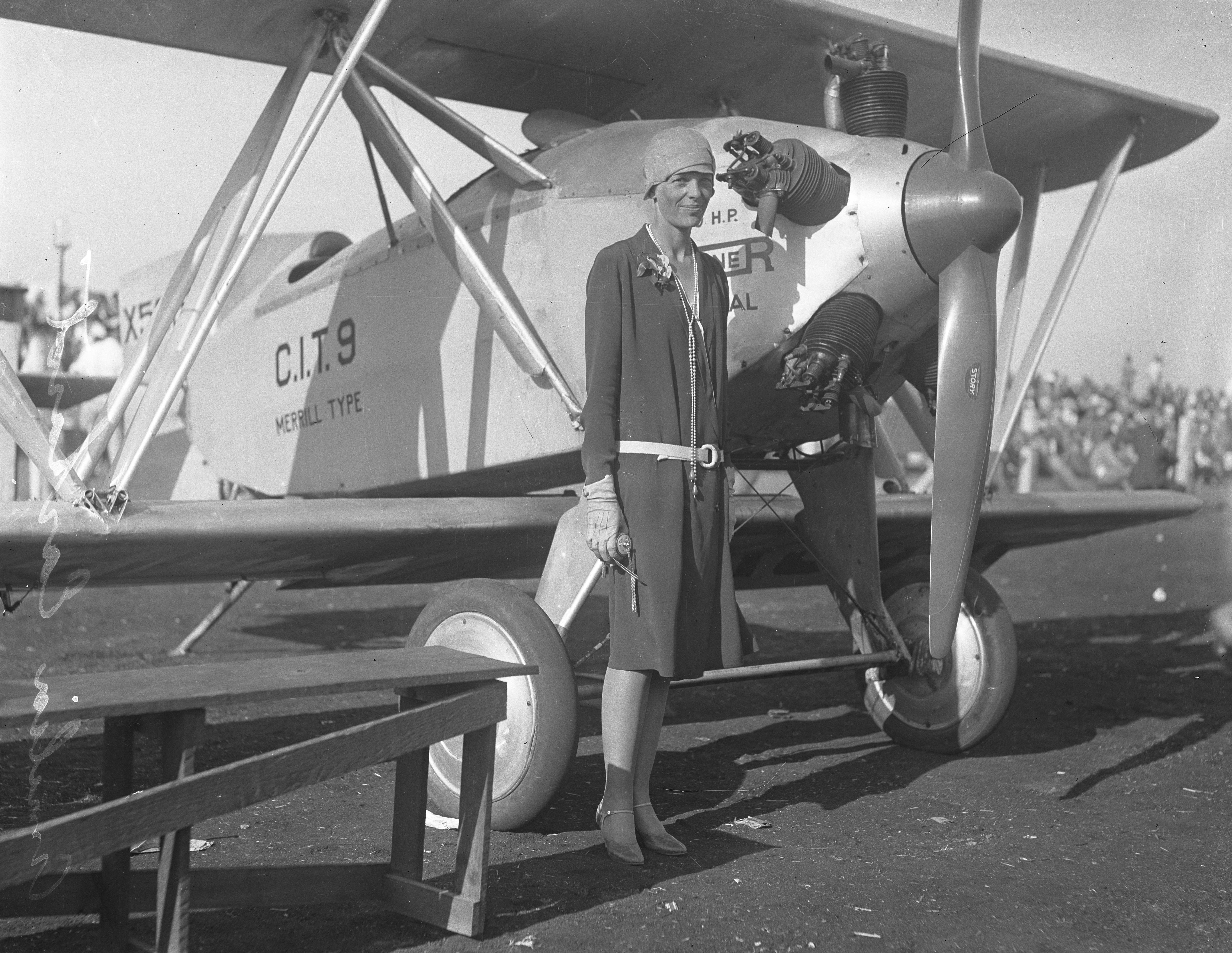 Amelia Earhart standing next to an aircraft. 